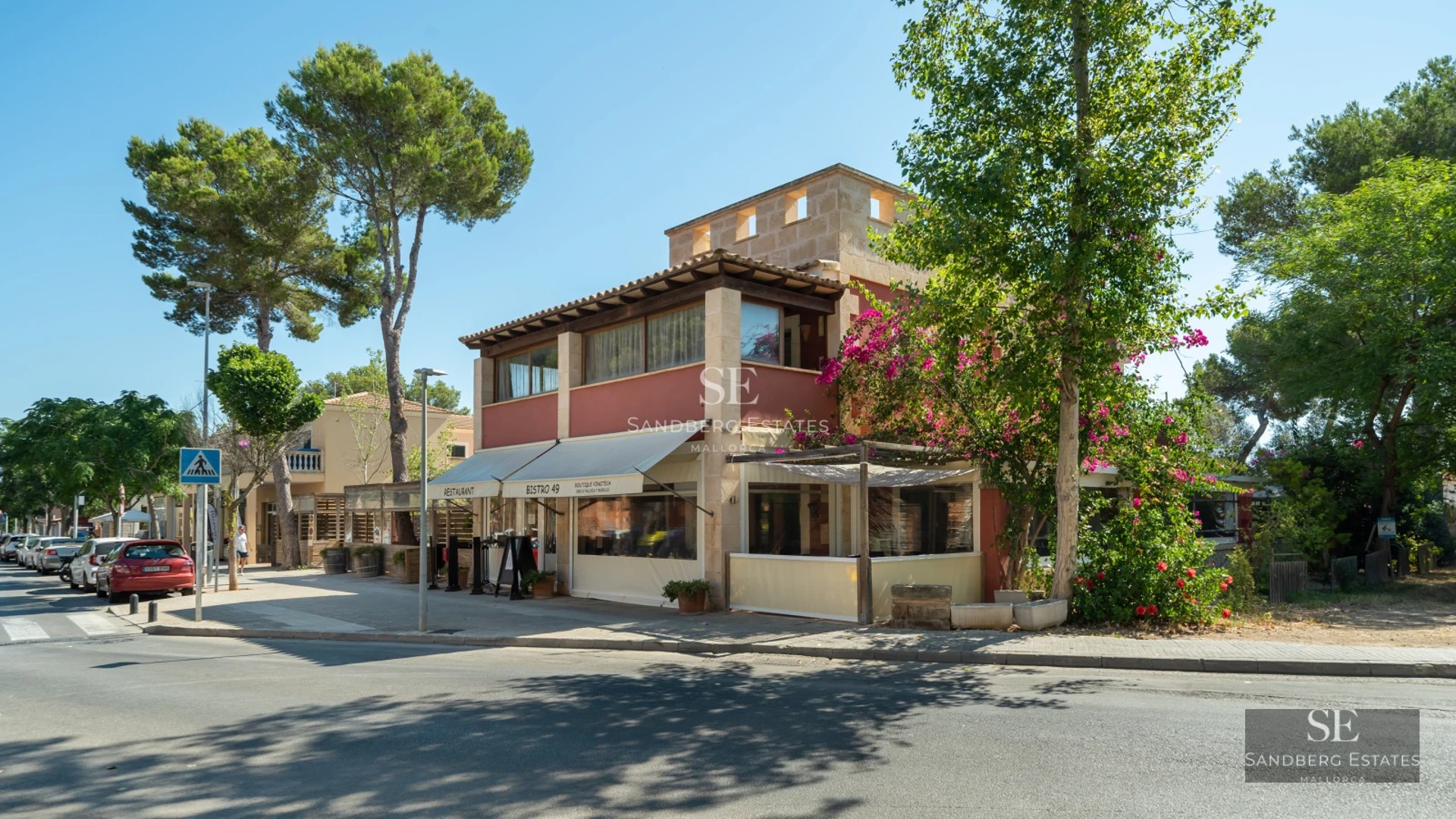 Spacious living room with floor-to-ceiling windows, natural light, light wood floors, and modern furniture. Garden and pool view.