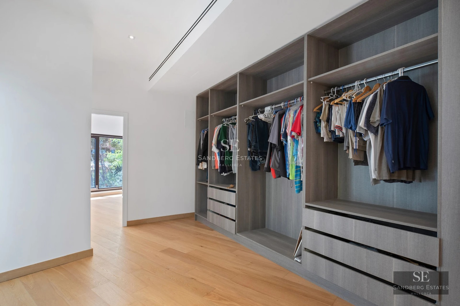 Image of a modern villa with a pool, large windows, and minimalist design. Lush garden and blue skies.