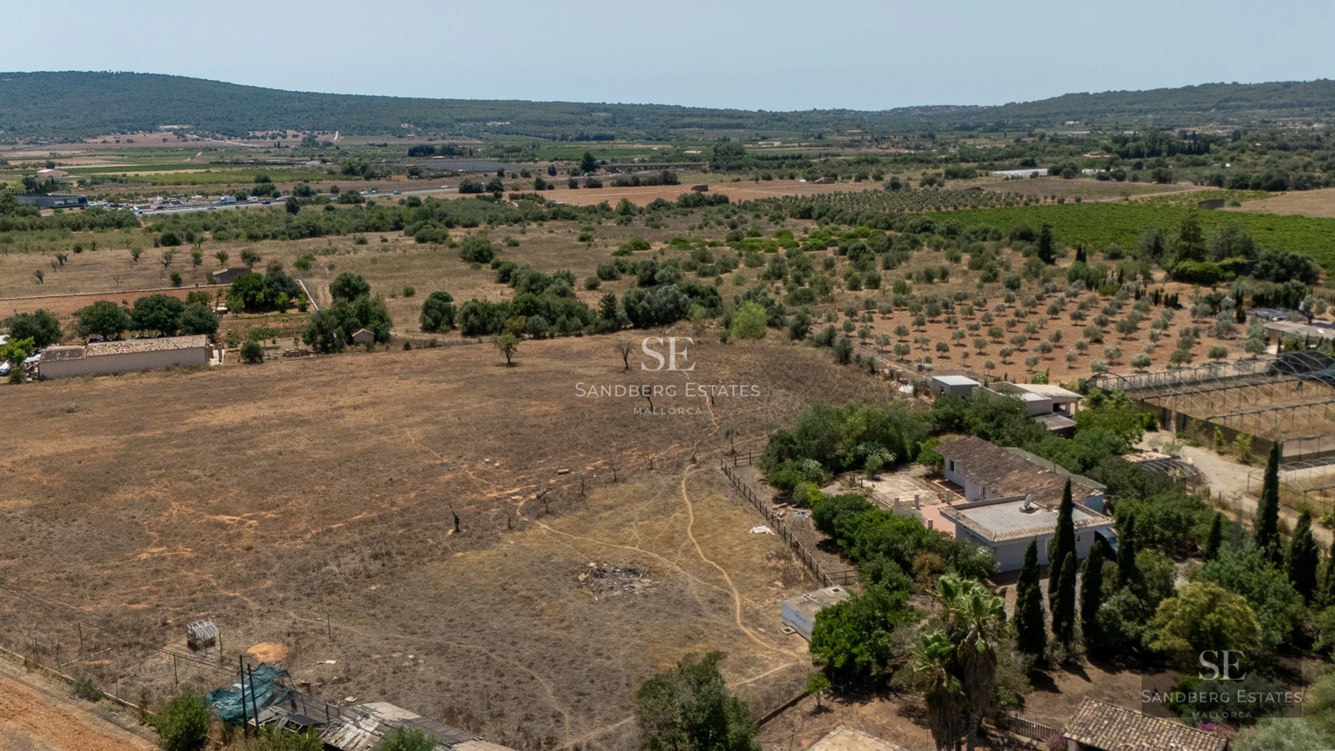 View of infinity pool with vanishing edge, spacious terrace, sun loungers, and modern house with large windows. Minimalist architecture.