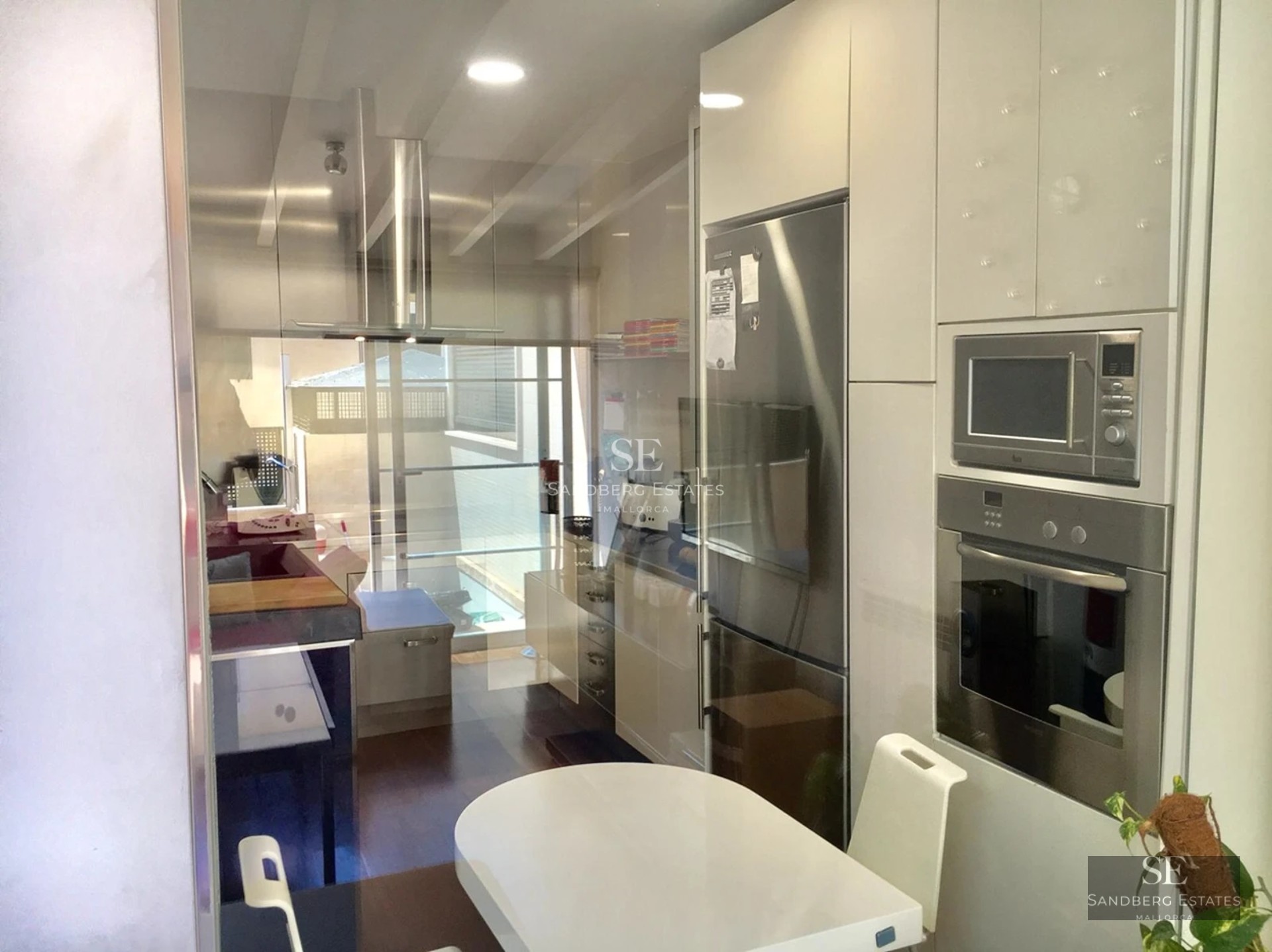 Spacious living room featuring panoramic windows, light wood floors, and a modern fireplace. Natural lighting and designer furniture.