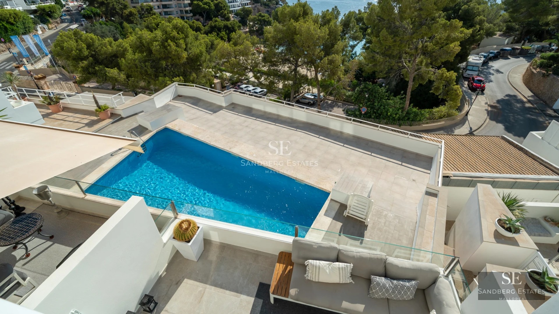 Luxurious living room featuring large windows, showcasing the outdoor pool. Modern design, natural lighting, and high-quality finishes.