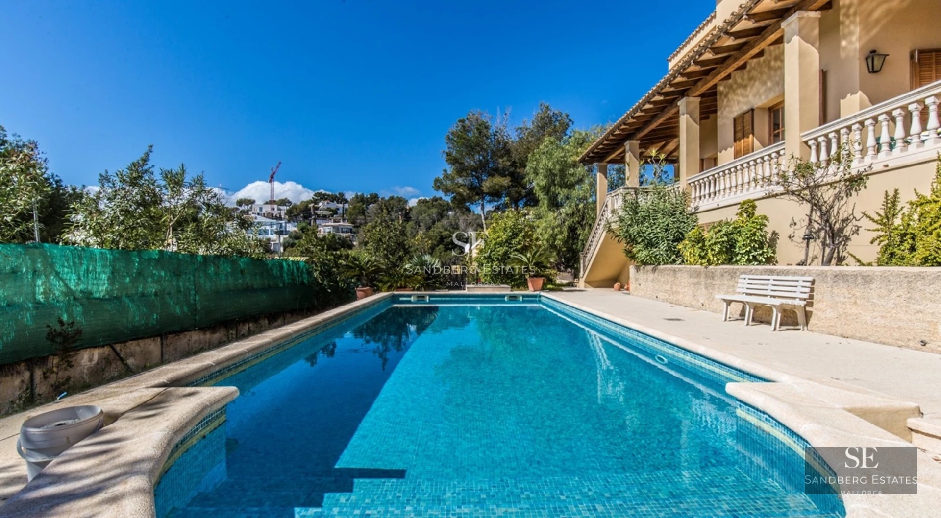 View of a modern villa with infinity pool, manicured garden, and spacious terraces. Sleek and contemporary design.