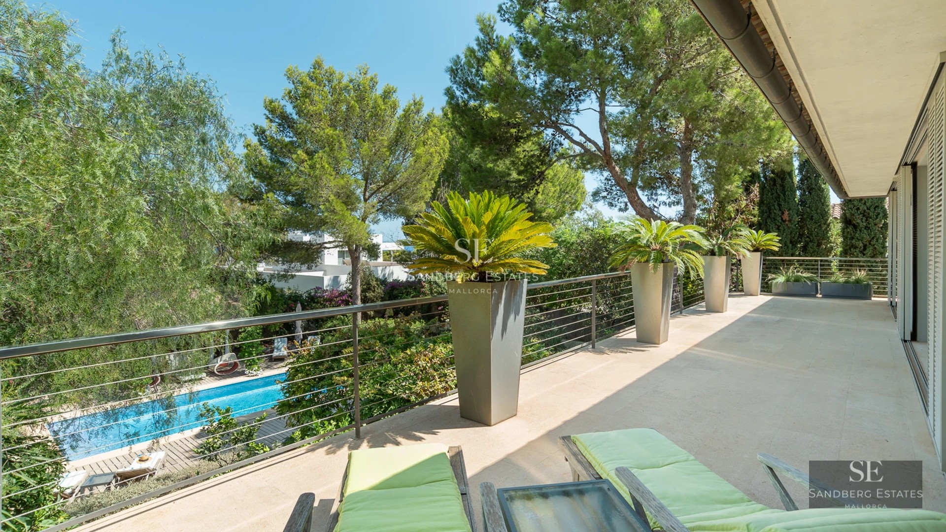 Sea view terrace, glass railing, modern furniture, pool and gardens. Sleek, minimalist design.