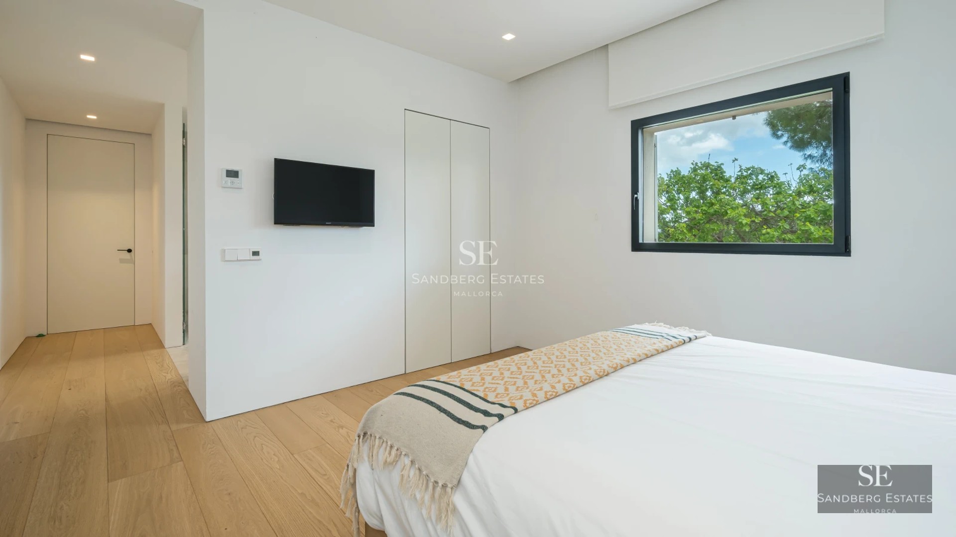 Spacious terrace with modern furniture, panoramic view, and minimalist design. Wood flooring and glass railing.