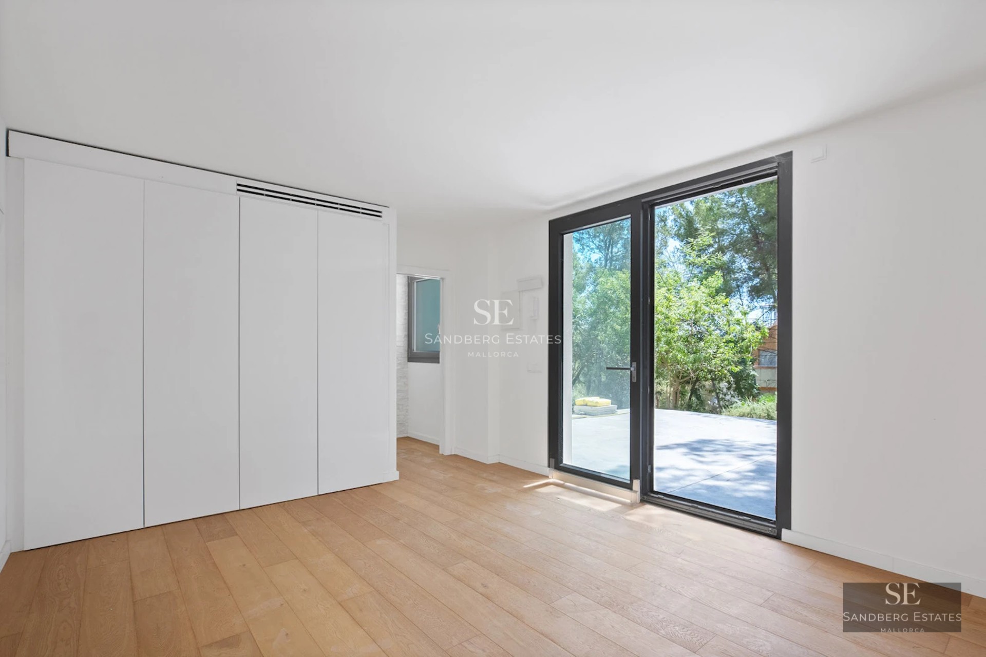 Wide view of a modern villa with a reflecting pool. Minimalist design with large windows and a spacious terrace.