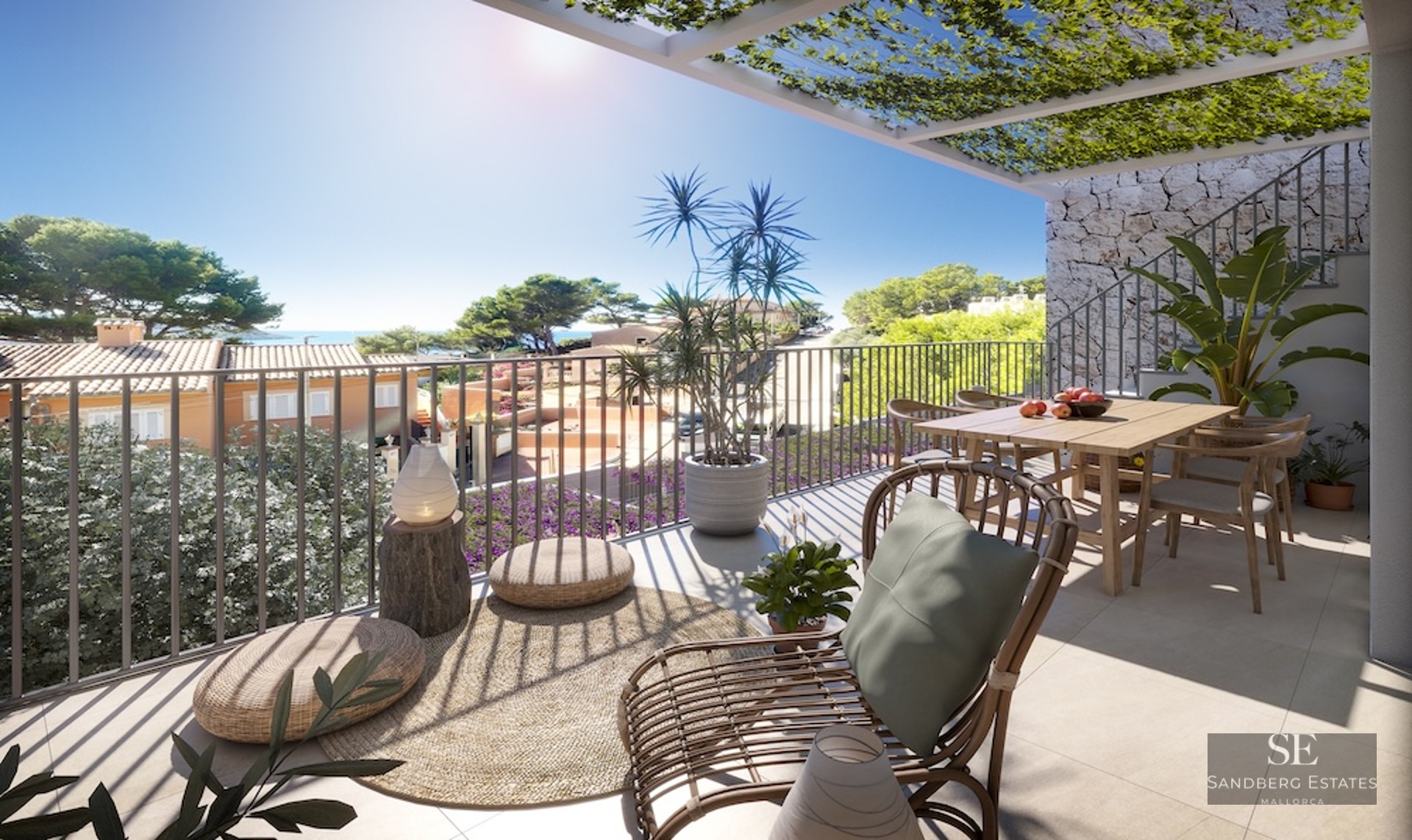 Sunny terrace with wooden dining table, rattan lounge chair, and vine-covered pergola overlooking the sea.