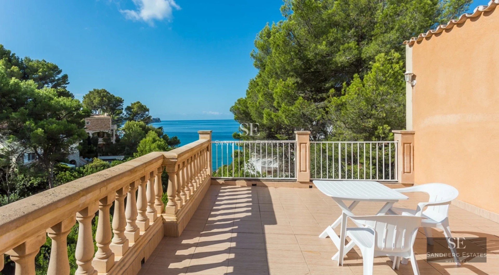 View of infinity pool with sun loungers and lush vegetation. Modern and elegant architecture with large windows.