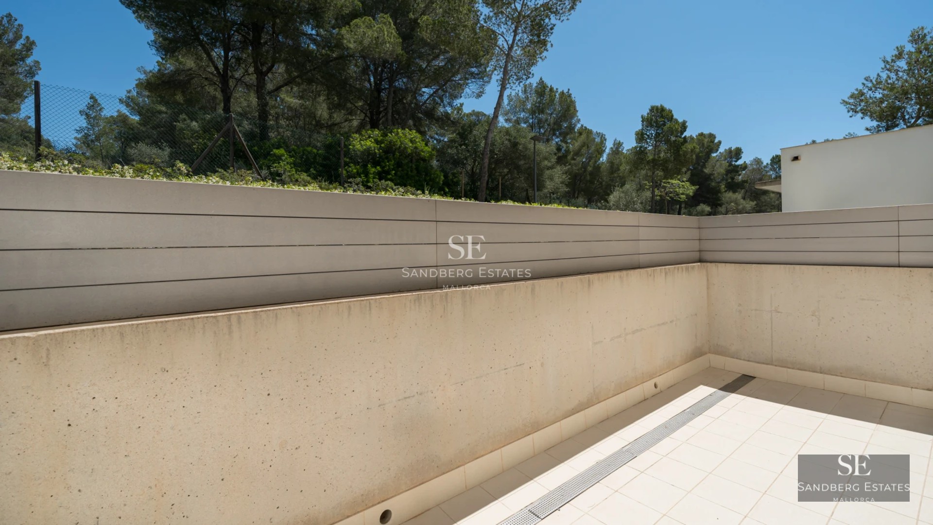 Spacious balcony with panoramic sea views. Modern design, glass railing, and elegant furniture. Ambient lighting.