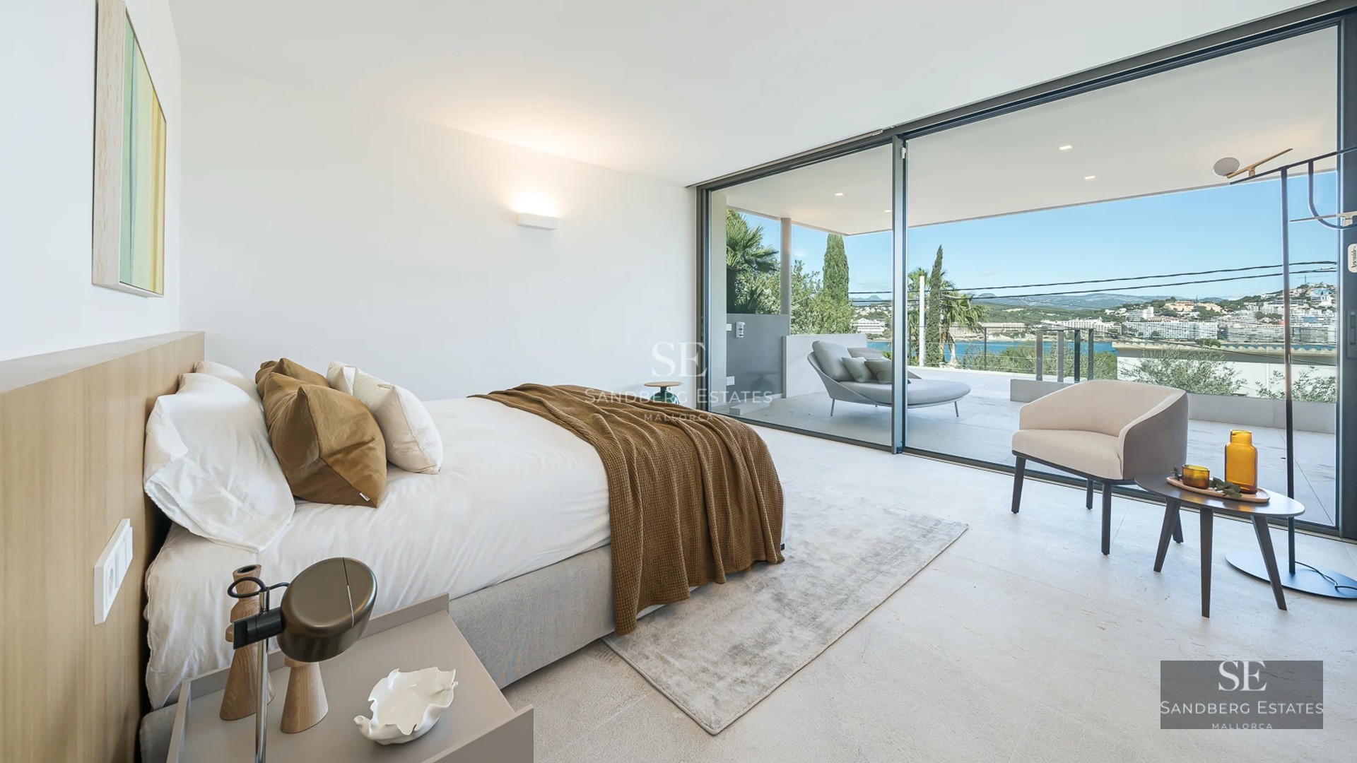 Bright interior with sea views. Modern design, light wood floors, large windows, and elegant furniture.