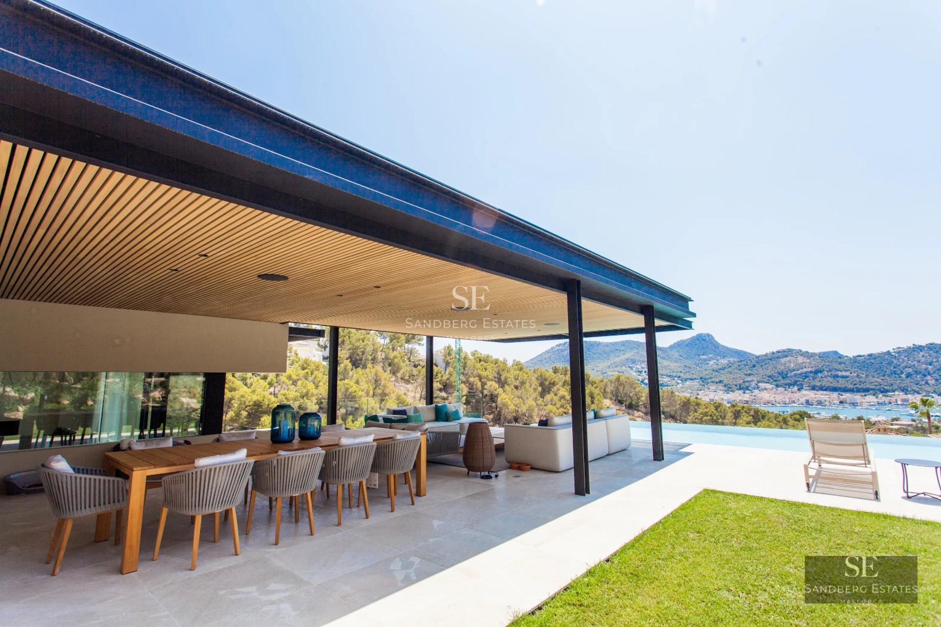 Spacious terrace with pool, sun loungers and panoramic views. Modern design with natural lighting and lush vegetation.