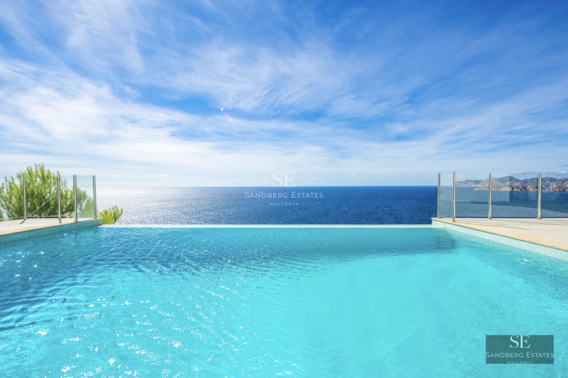 Bright, spacious living room with large windows, light wood floors, and minimalist design. Overlooking garden and pool.