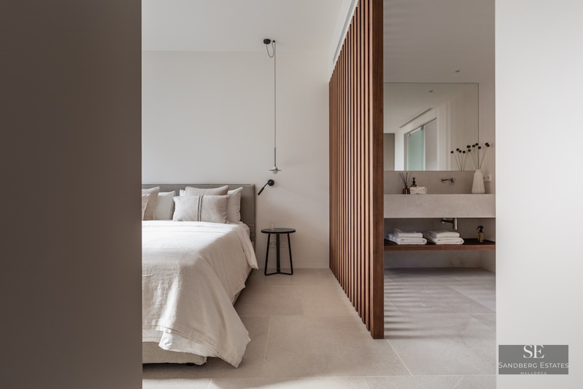 Modern minimalist master bedroom featuring a wooden slat divider and integrated ensuite bathroom with stone vanity.