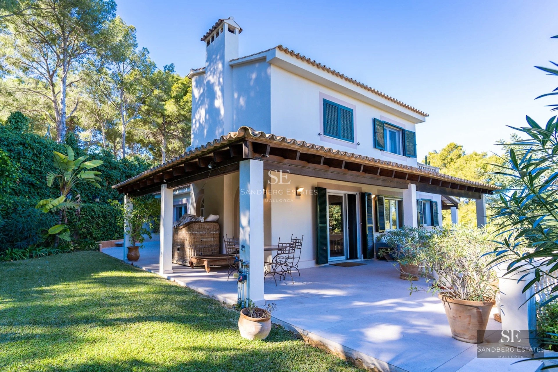 View of a luxurious villa with an infinity pool, large garden, and modern design. Large windows illuminate the interiors.