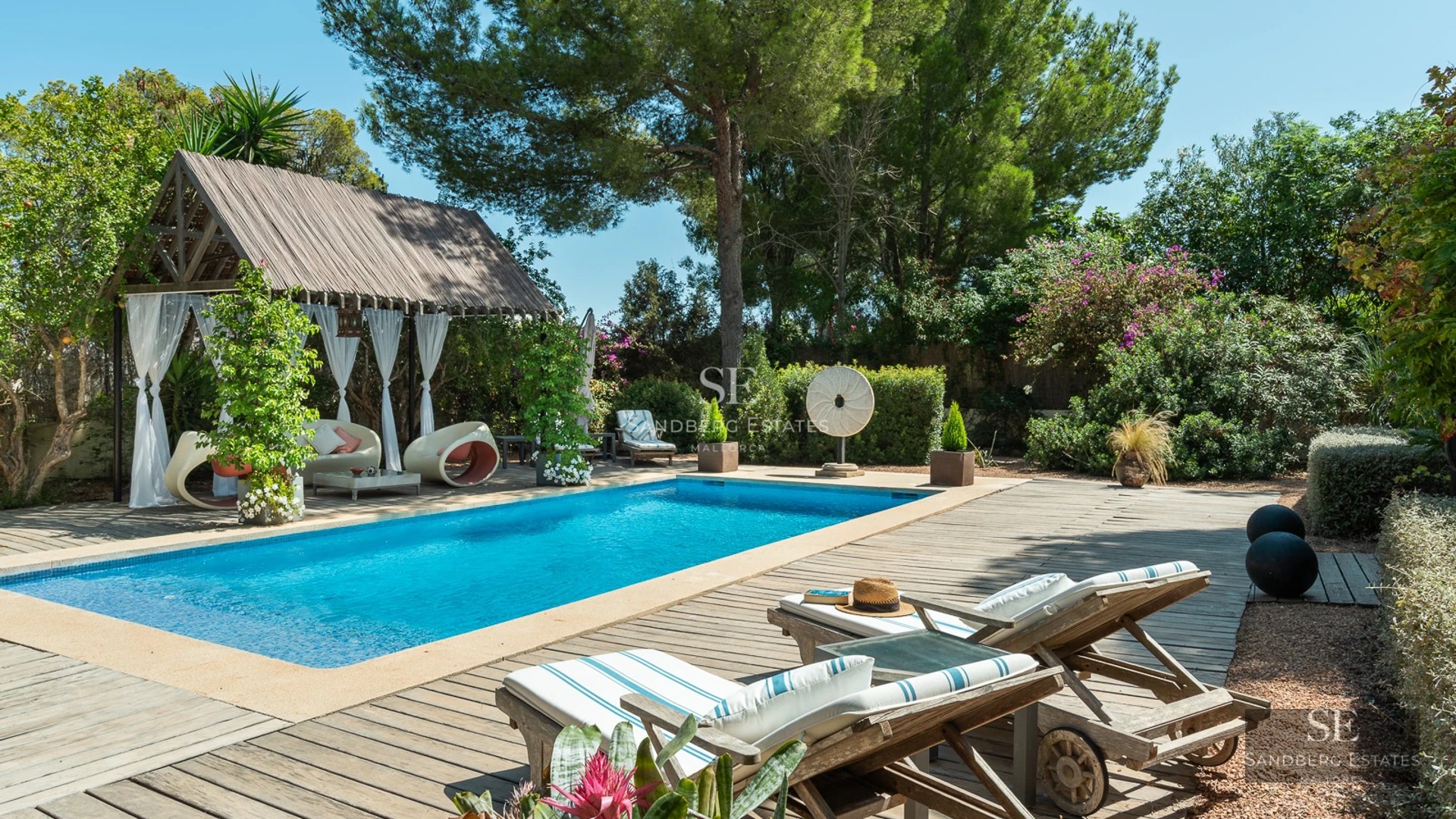 Exterior view of a modern villa with reflecting pool, large windows, glass balcony, and lush garden. Minimalist architecture.