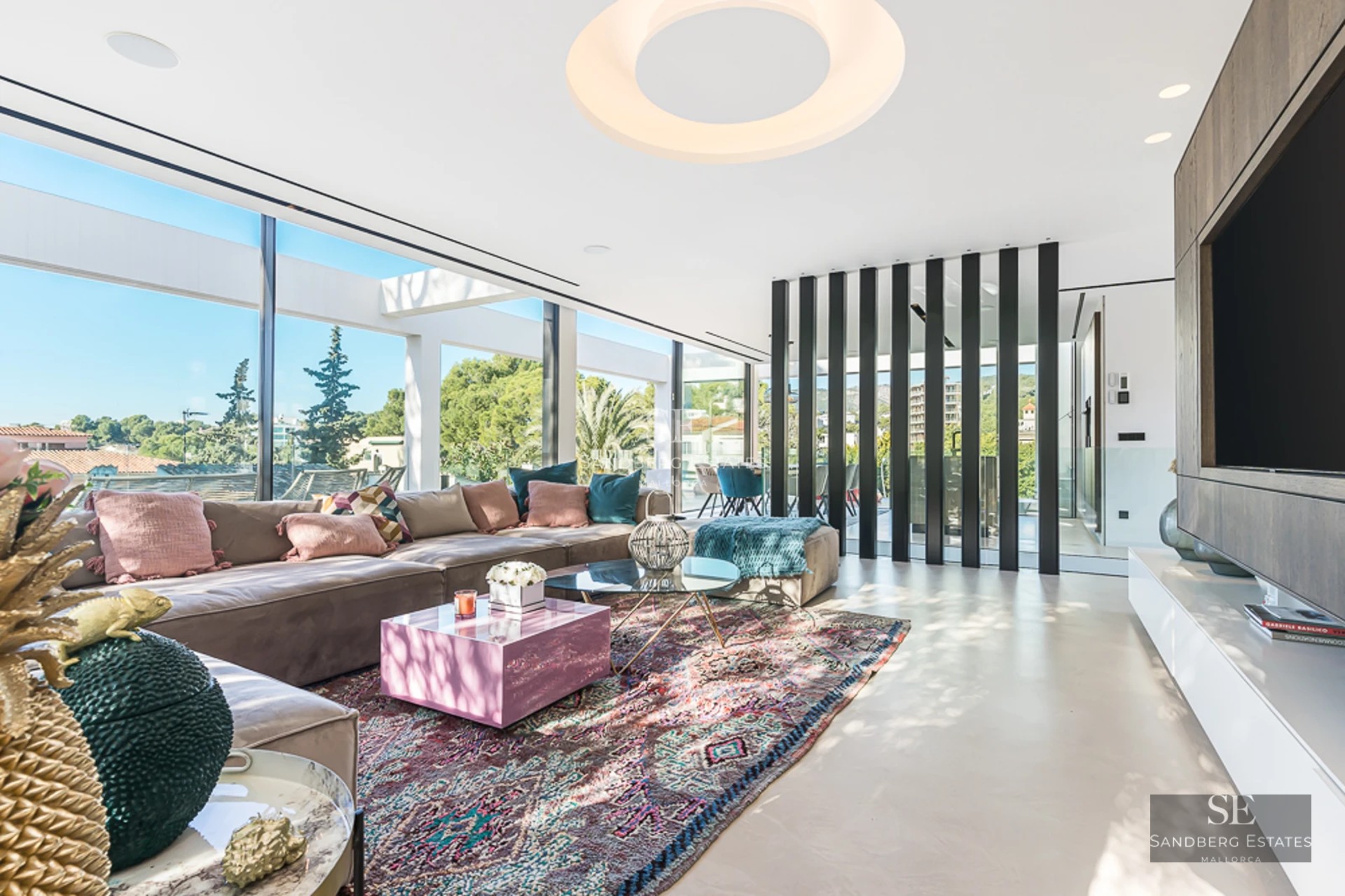 Spacious balcony with panoramic views. Glass railing, outdoor furniture, and abundant natural light. Modern and elegant design.