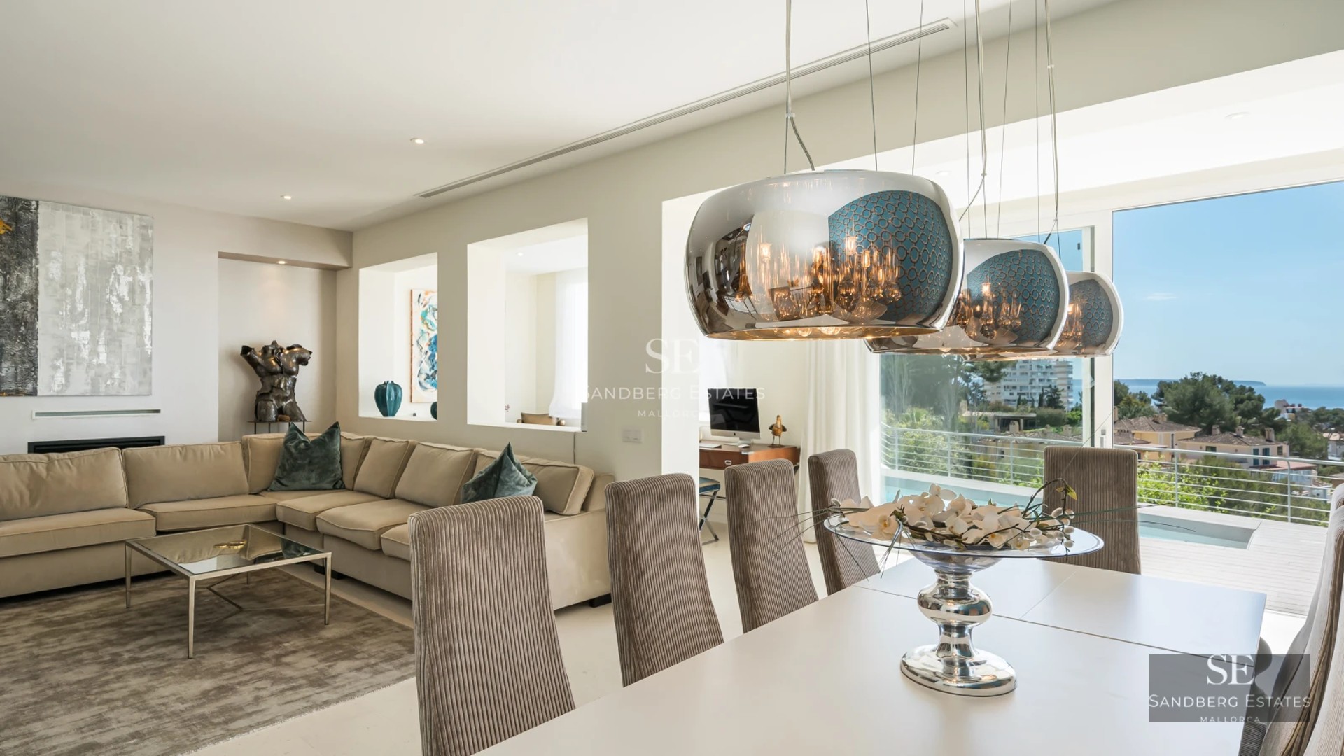 View of a luxurious villa featuring an infinity pool, lush gardens, and modern architecture. Natural lighting.