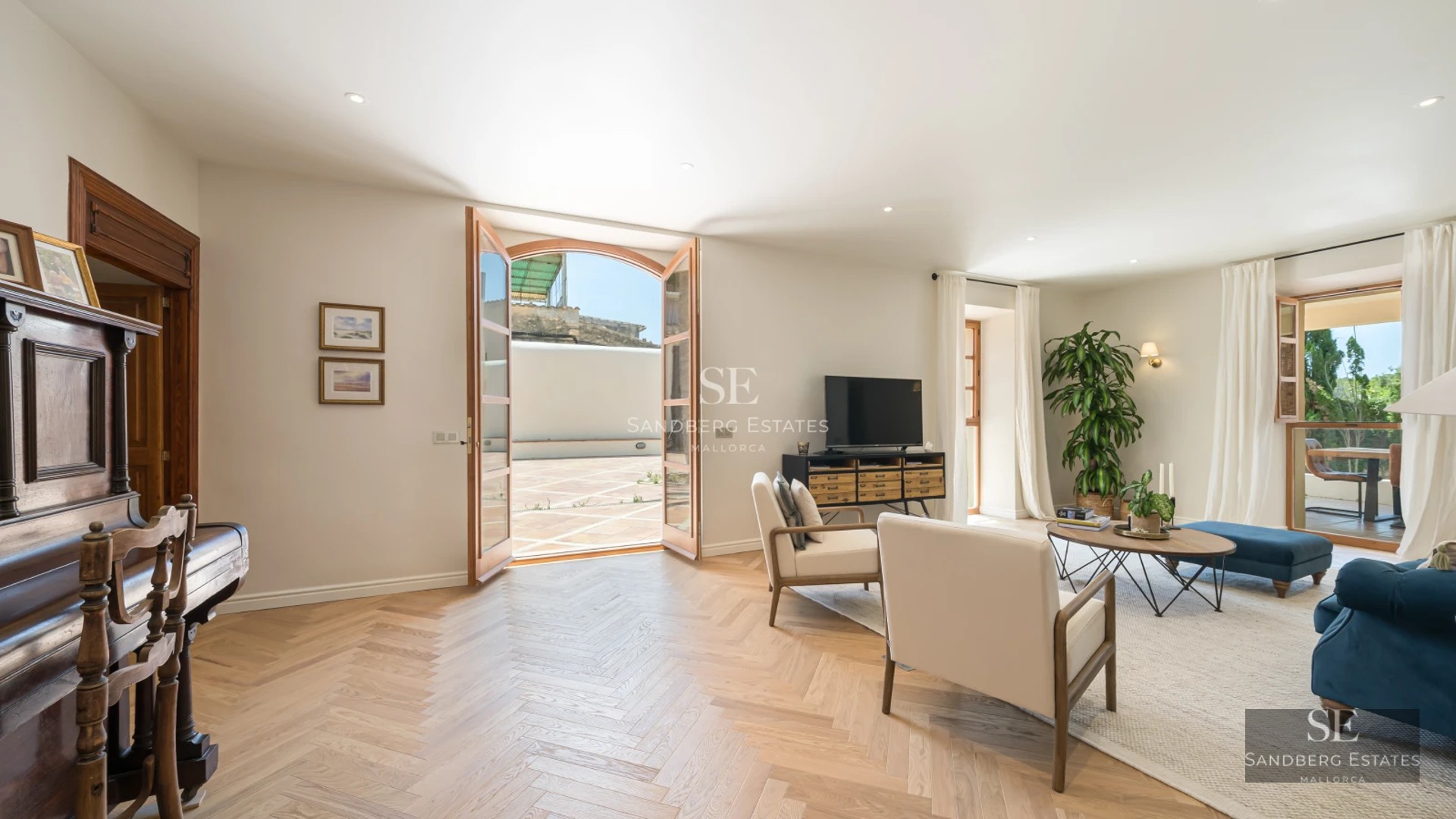 Bright living room with large windows, modern furniture, light wood flooring, and spectacular sea views. Elegant and functional design.
