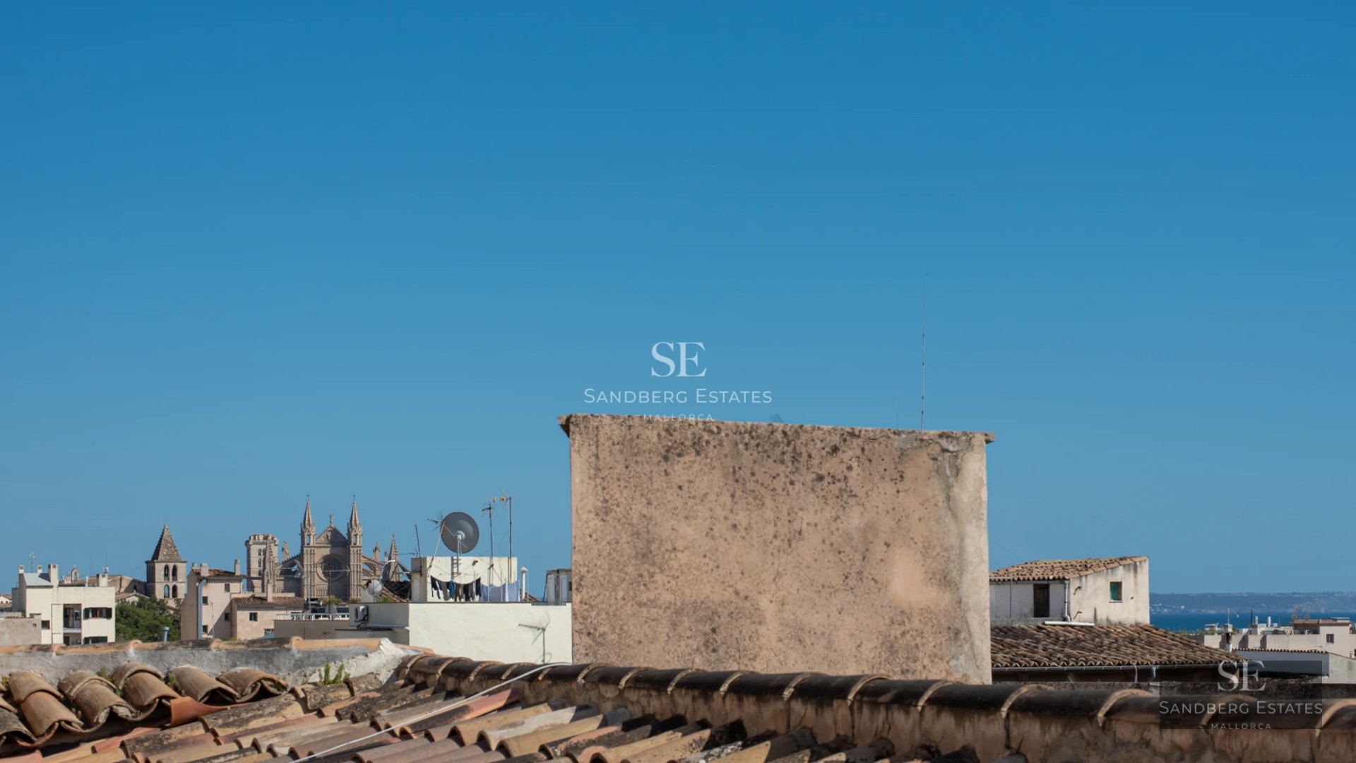 View of an elegant pool bordered by lawn and sun loungers, surrounded by modern architecture with large windows.