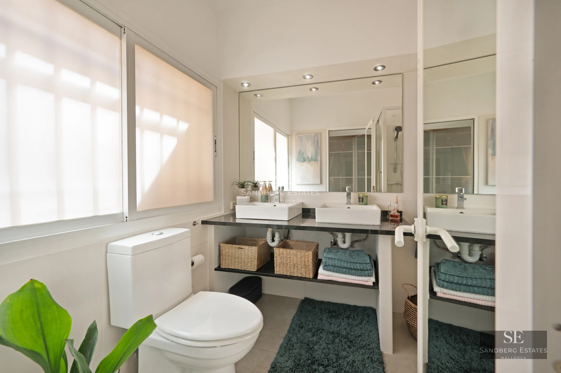 Panoramic view of a modern living room with large windows offering stunning sea views and access to a terrace.