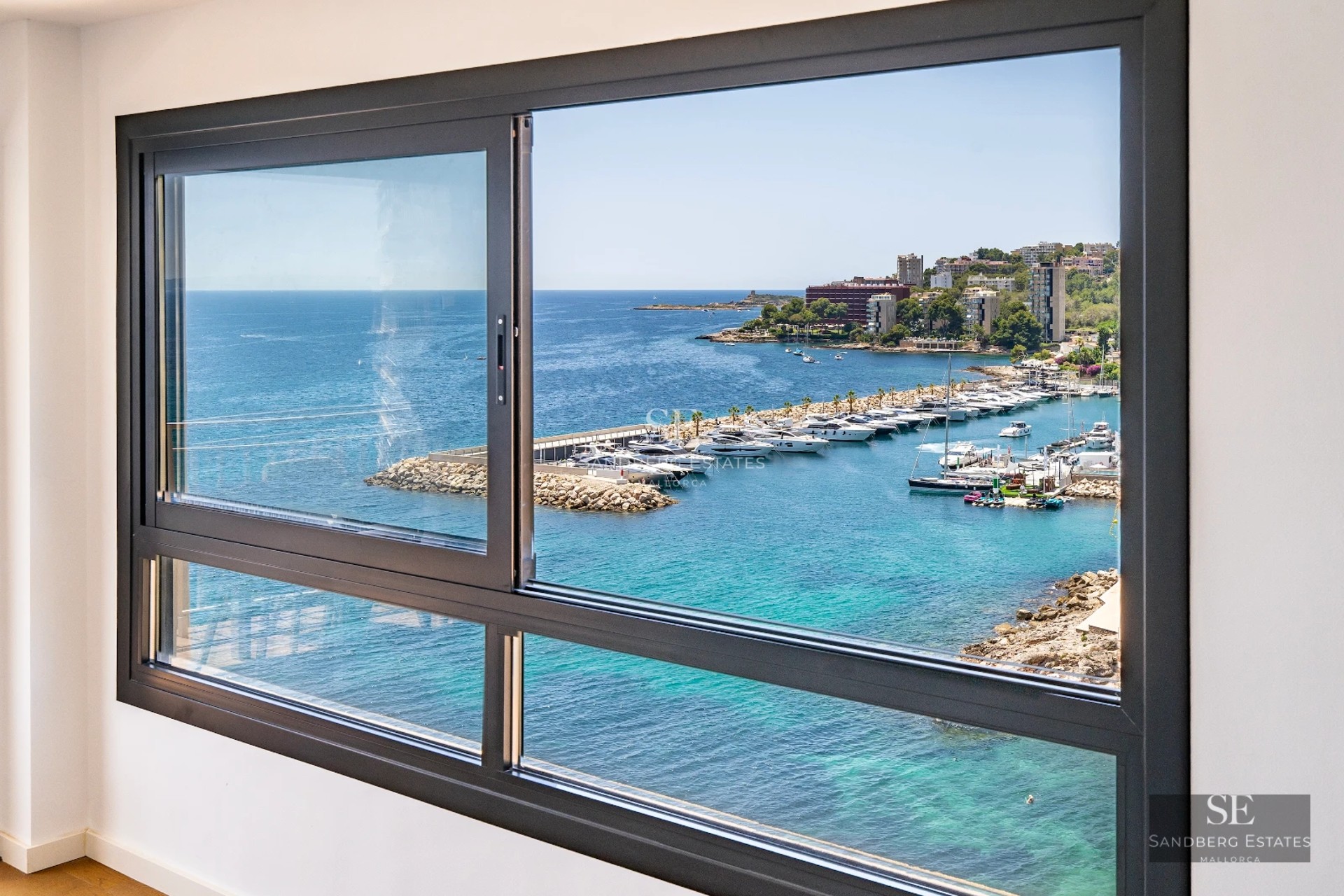 Spacious balcony with sea view. Modern design, glass railing, outdoor furniture. Natural and warm lighting.