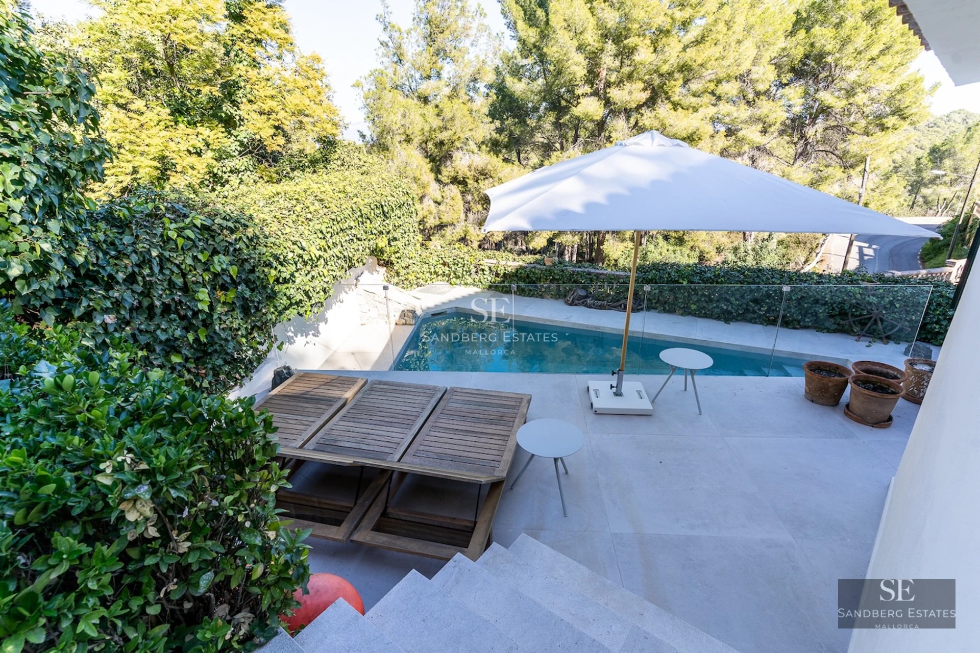 Spacious balcony with panoramic sea views. Modern design, glass railing and elegant outdoor furniture.