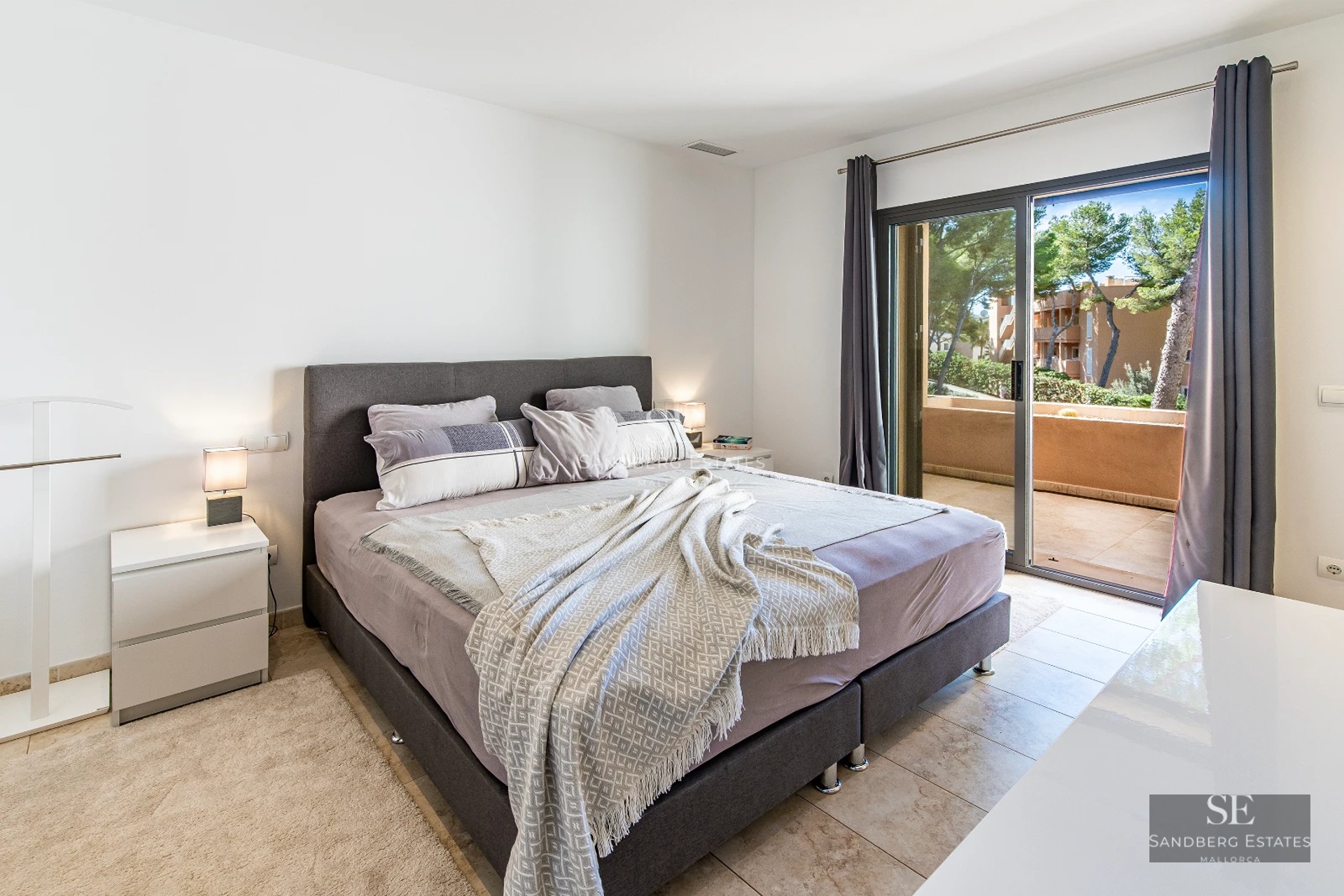 Large pool surrounded by a modern house with large windows and lush gardens. Contemporary and elegant architecture.