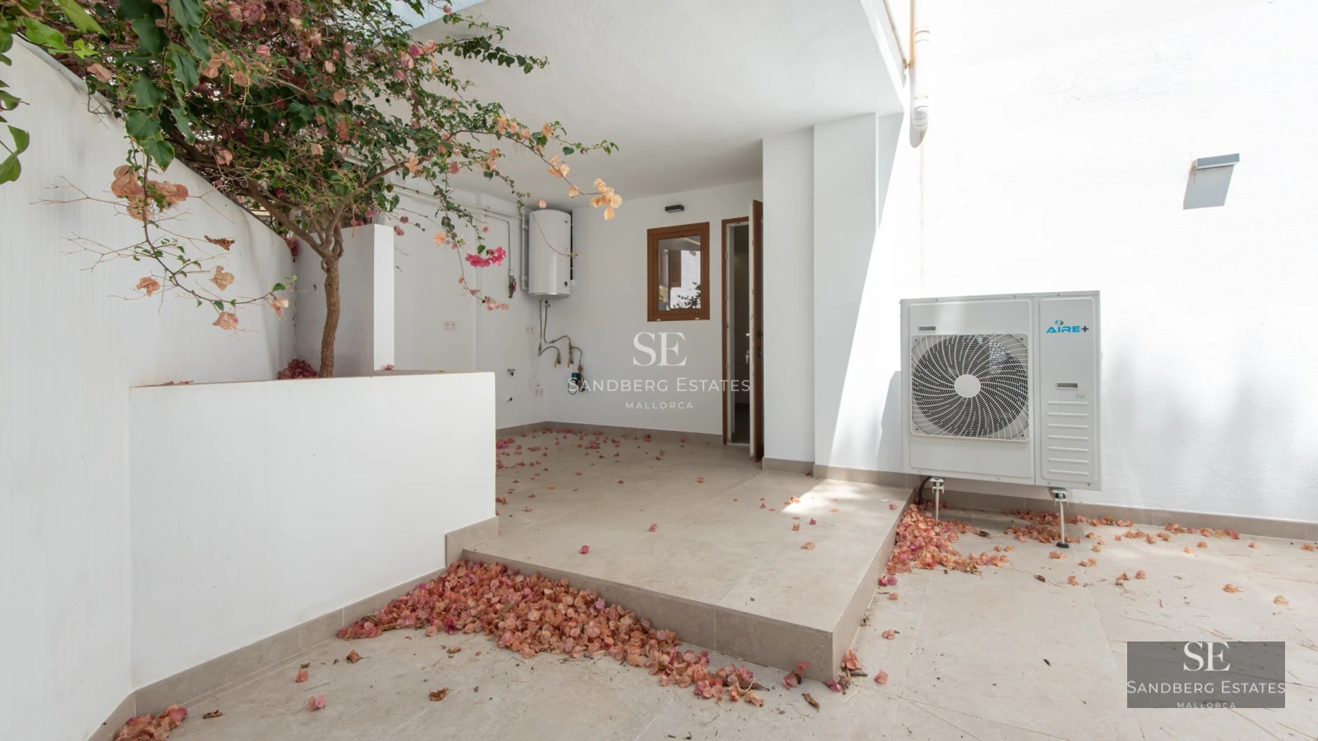 Spacious living room with fireplace, large windows, and terrace access with views. Elegant furniture and modern decor.