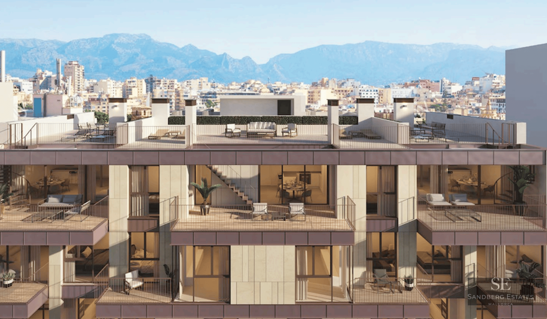 Modern building facade featuring multiple balconies, rooftop terraces, and a backdrop of city and mountains.