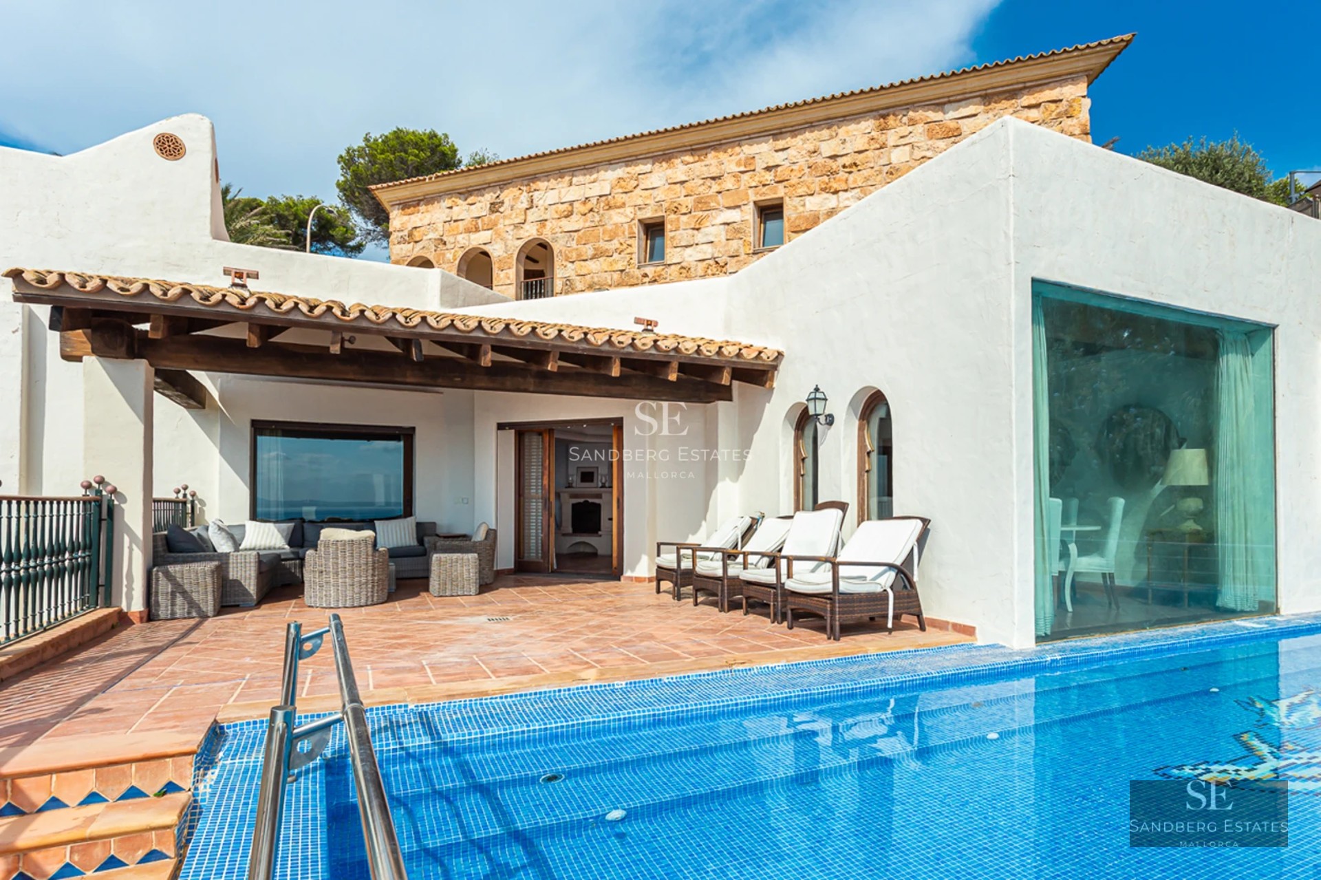 Vaste terrasse avec piscine à débordement et vue panoramique. Design moderne, mobilier d'extérieur élégant et végétation luxuriante.