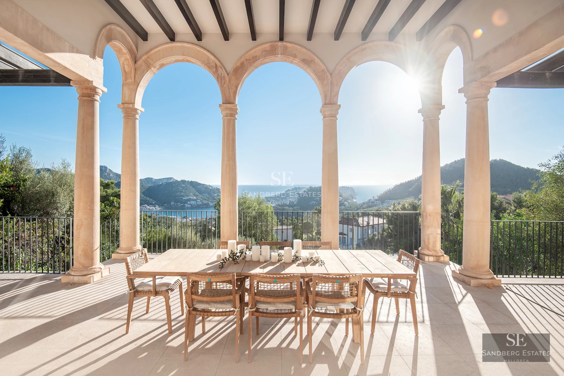 View from balcony with glass railing, infinity pool and sea in the background. Modern and elegant design. Decorative plants.