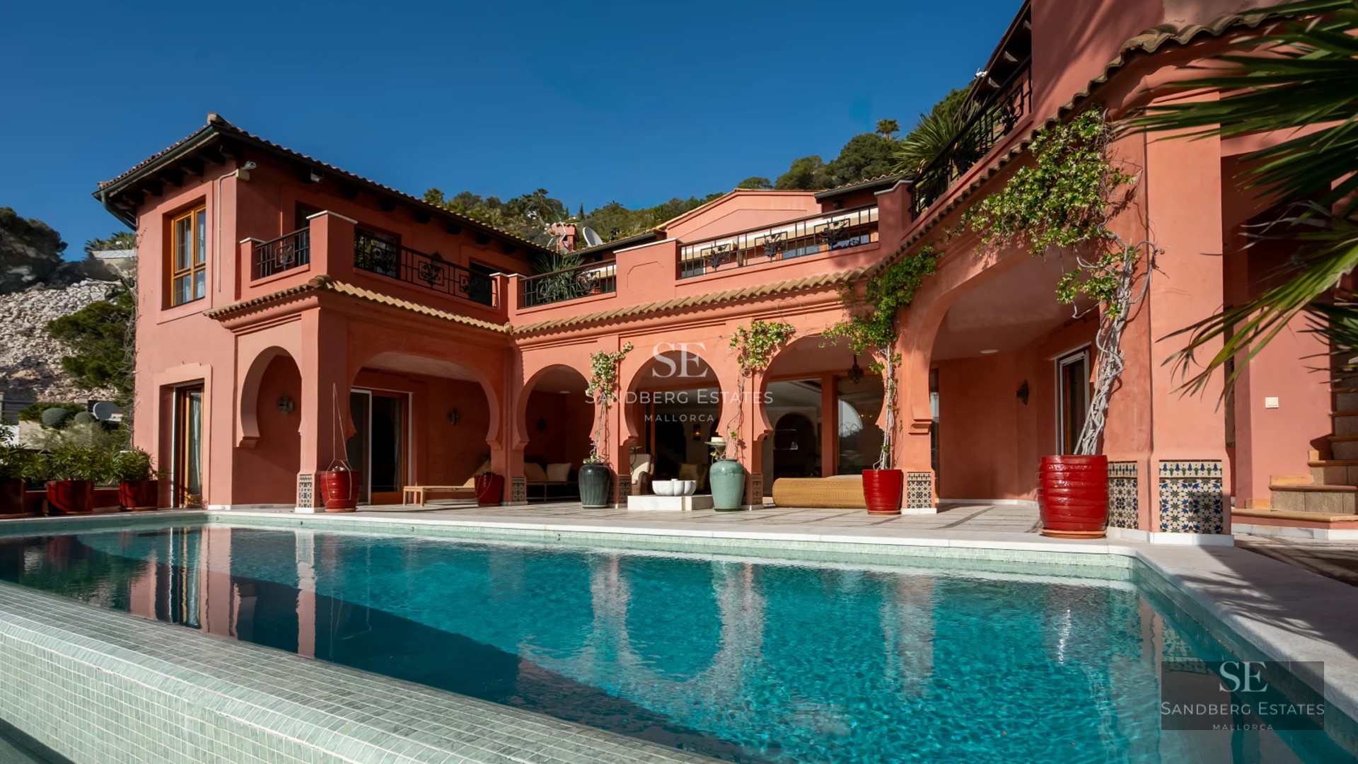 Spacious balcony with panoramic sea views. Sleek modern design featuring glass railings and minimalist outdoor furniture.