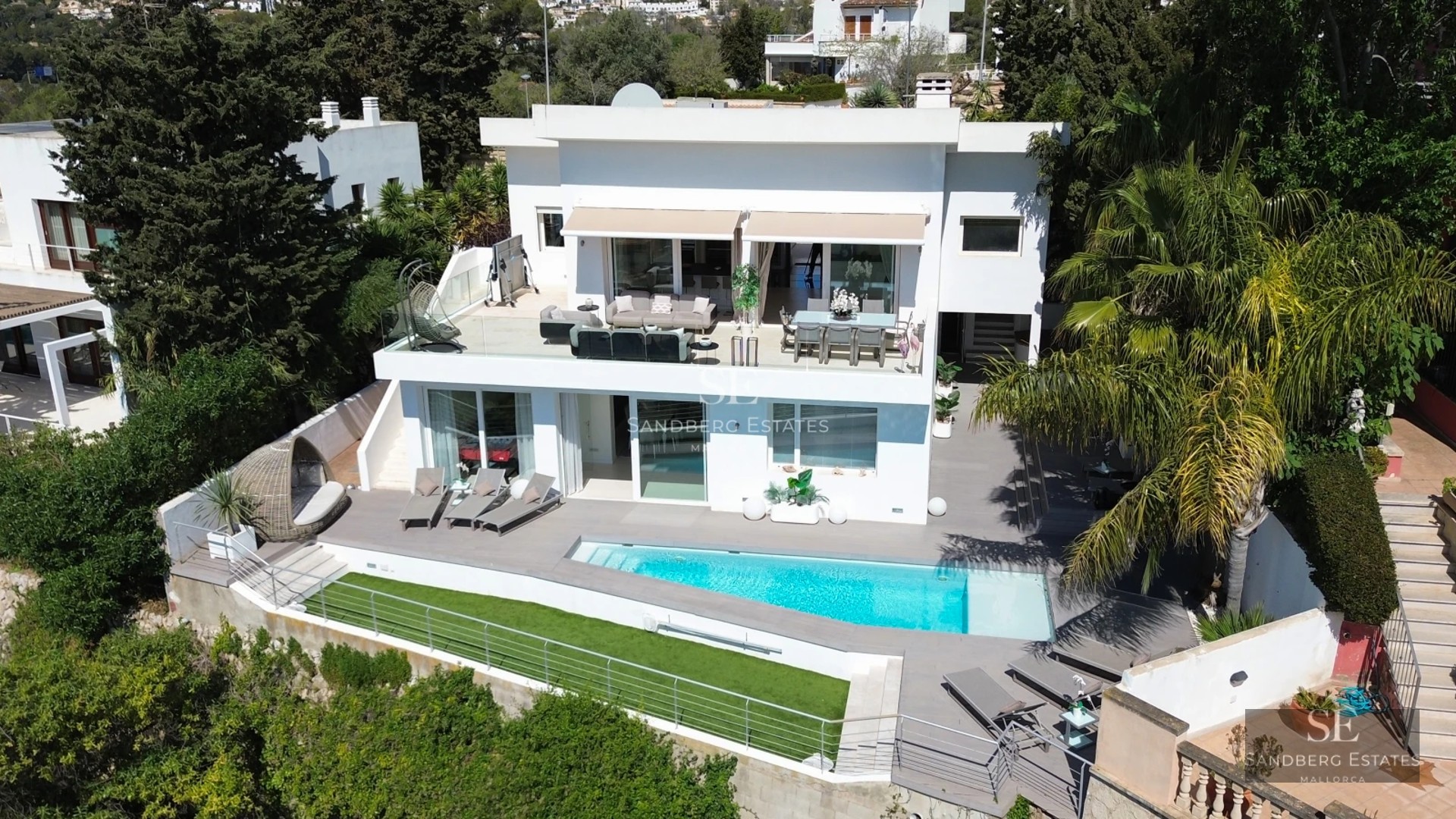 Infinity pool with sea views, modern sun loungers and lush vegetation. Minimalist and elegant design.