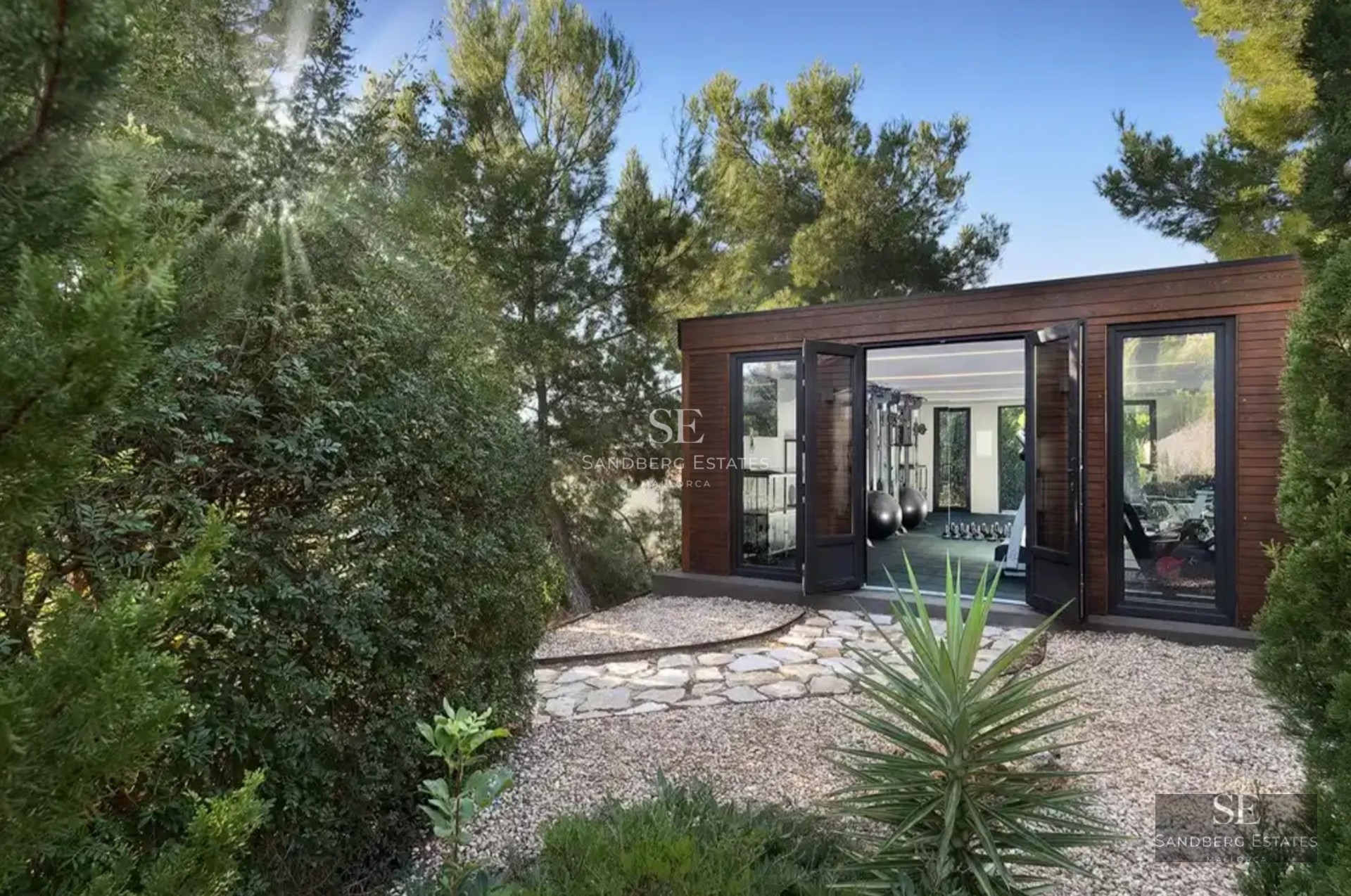 Spacious living room with floor-to-ceiling windows, modern furniture, sea view, and balcony. Bright and elegant design with natural touches.
