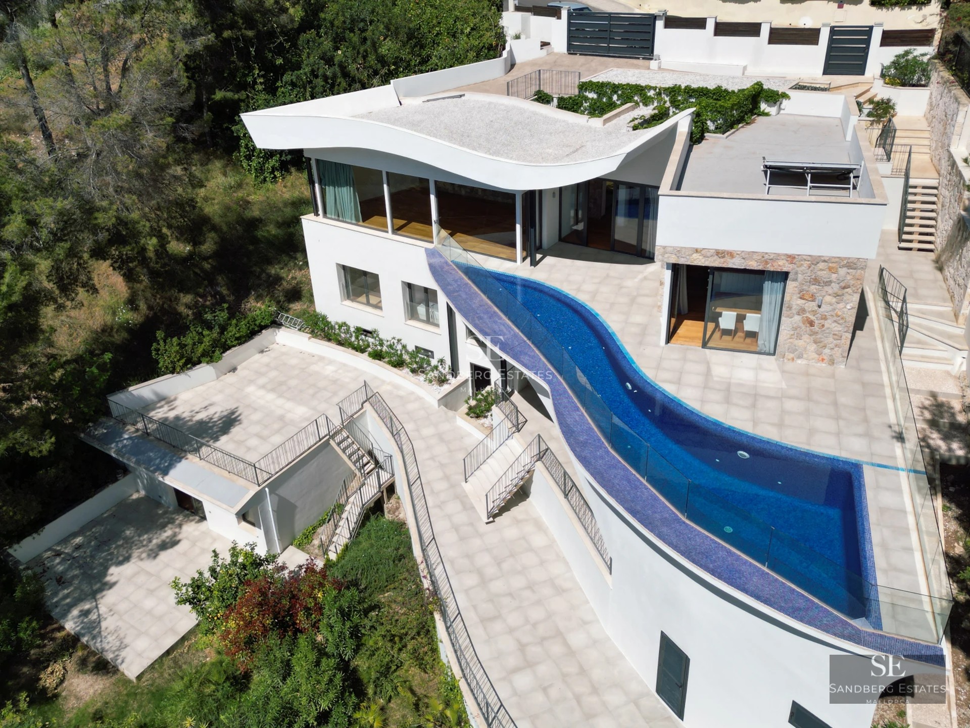 Bright living room with floor-to-ceiling windows offering sea view. Modern furniture, light wood floors and access to the terrace. Elegant minimalist design.