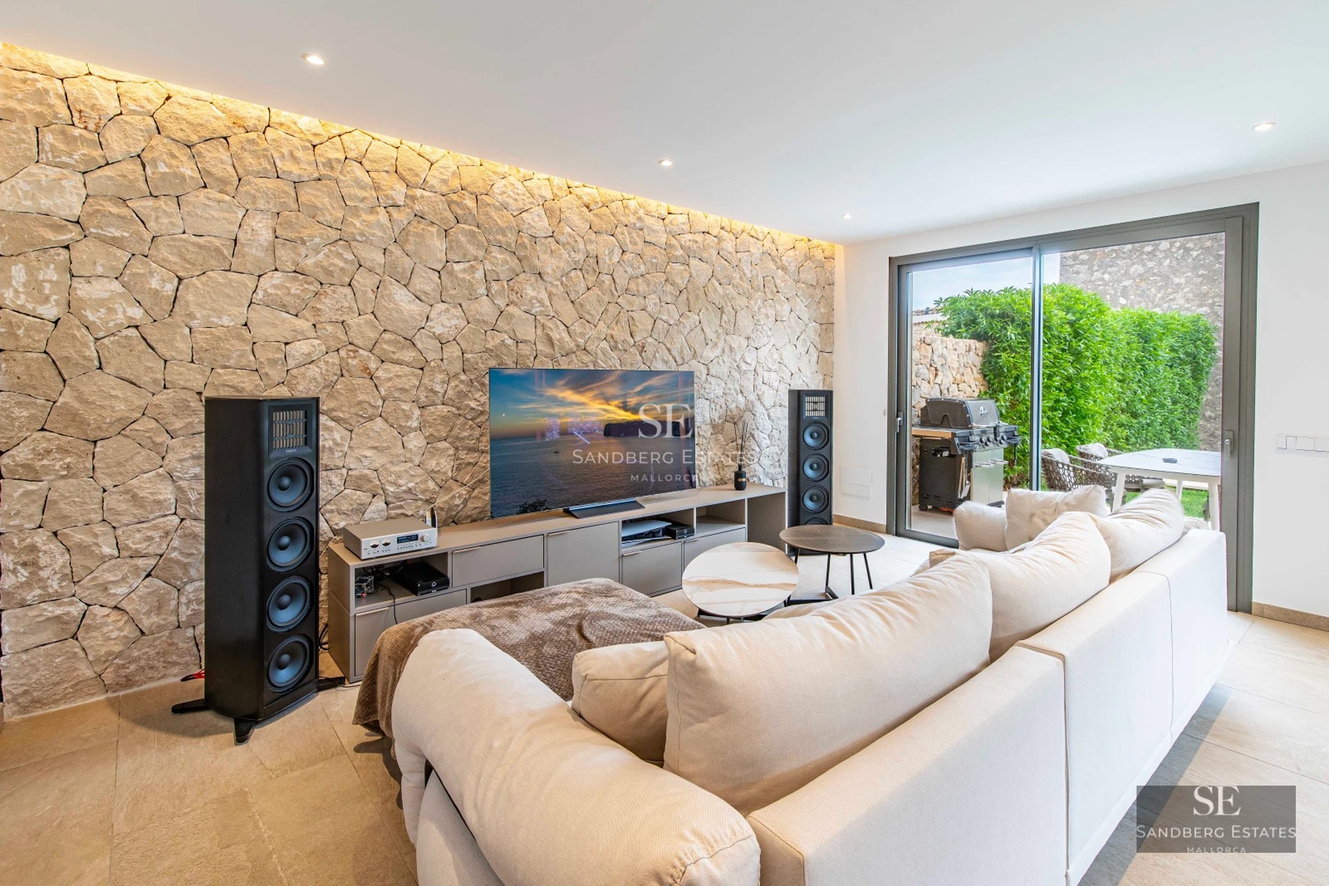 Exterior view of a modern villa featuring an infinity pool, lush garden, and contemporary architecture. Warm lighting.
