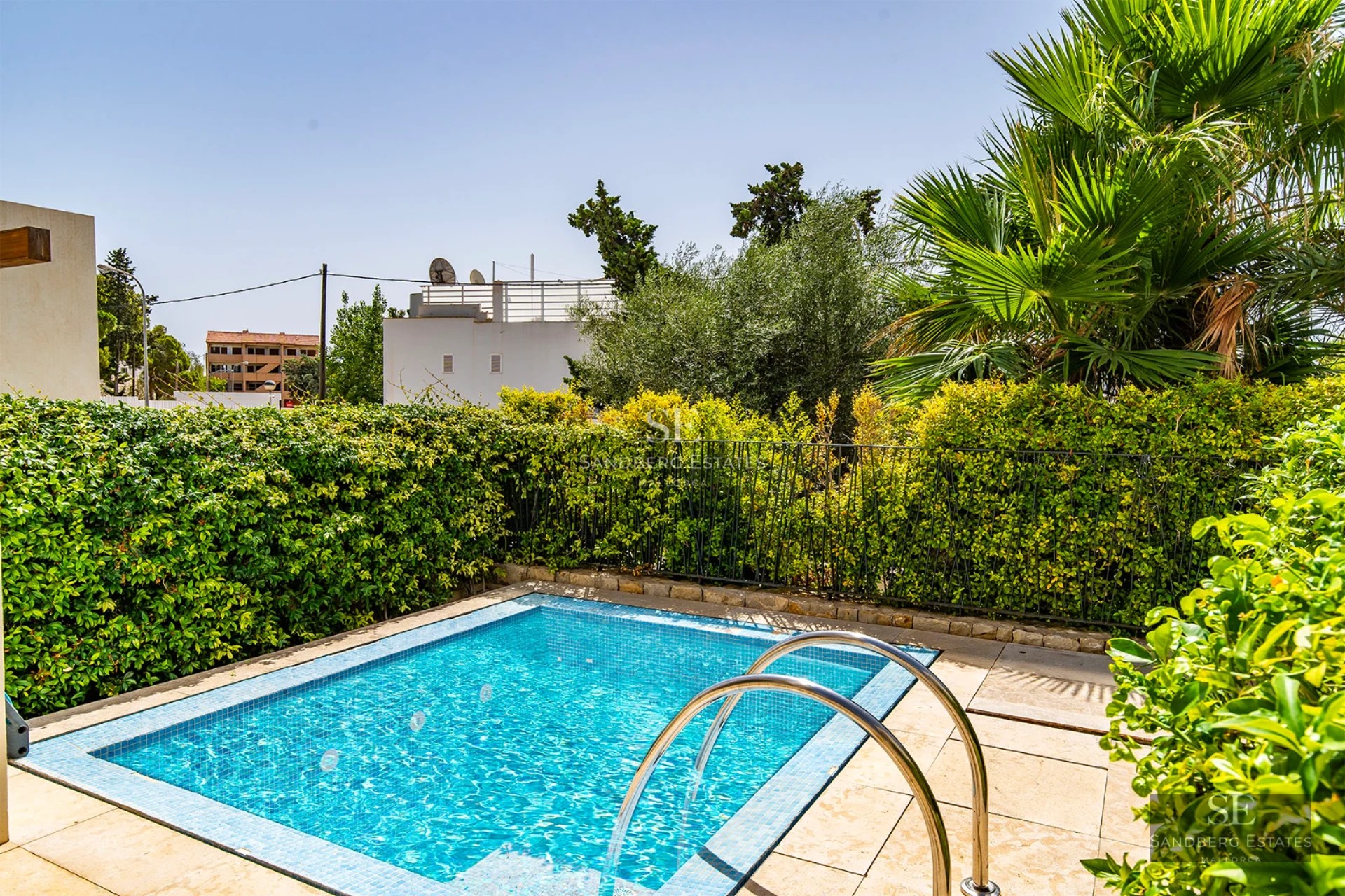 Spacious living room with floor-to-ceiling windows, wood floors, modern fireplace, and stunning views. Grey sofas, glass coffee table. Contemporary design.