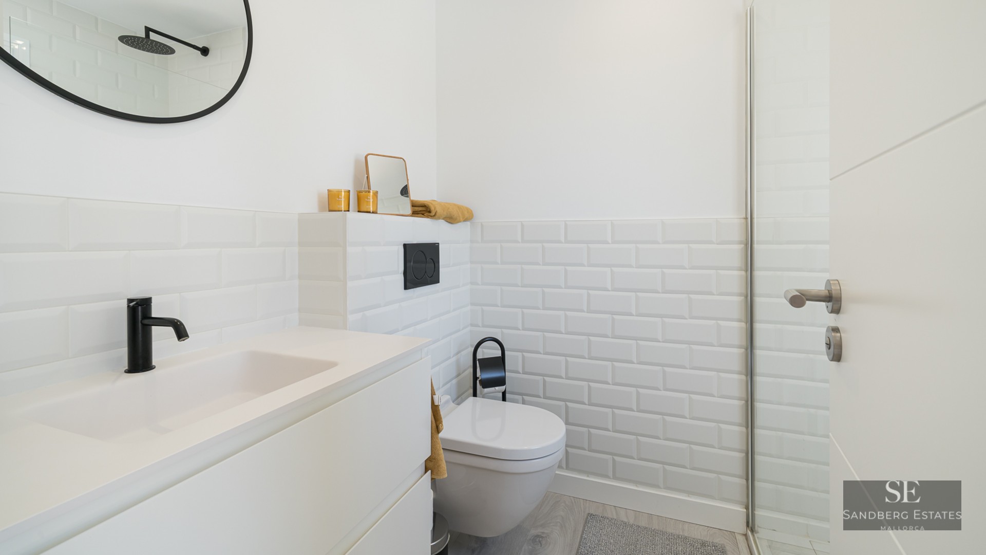 Modern white bathroom featuring subway tiles, black fixtures, and a sleek minimalist vanity.