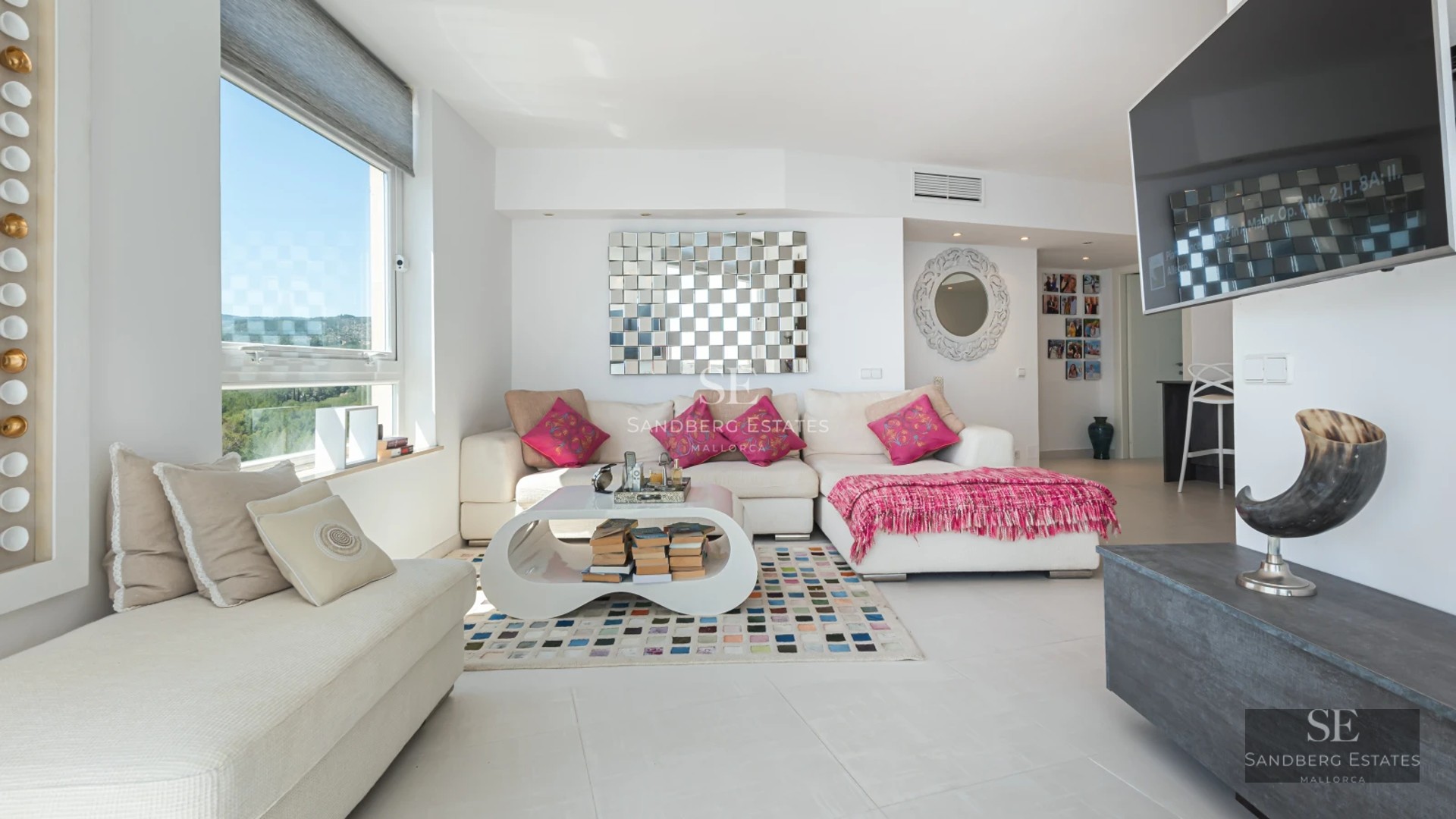 Aerial view of a modern residence featuring an infinity pool, expansive terraces, and lush surrounding greenery.