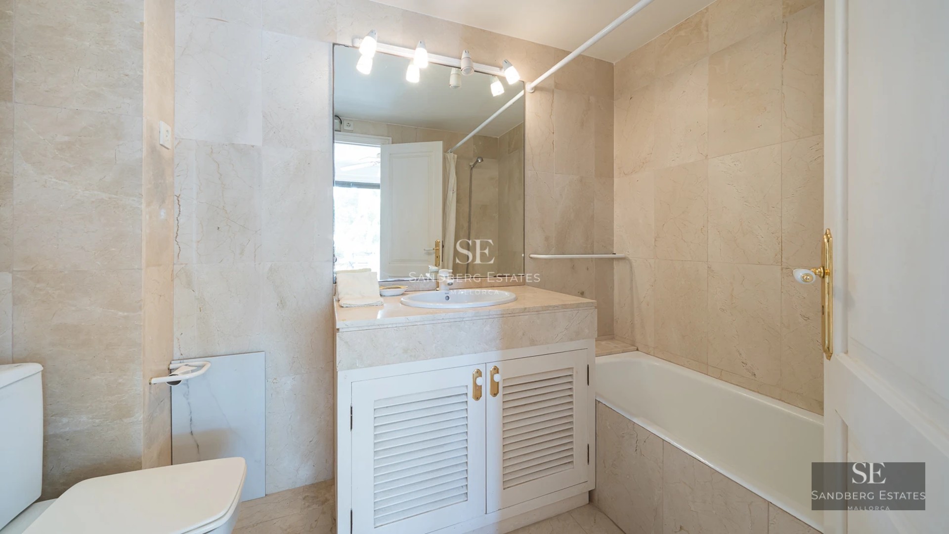 Spacious balcony with sea view, glass railing, wooden floor, and modern furniture. Minimalist and bright design.