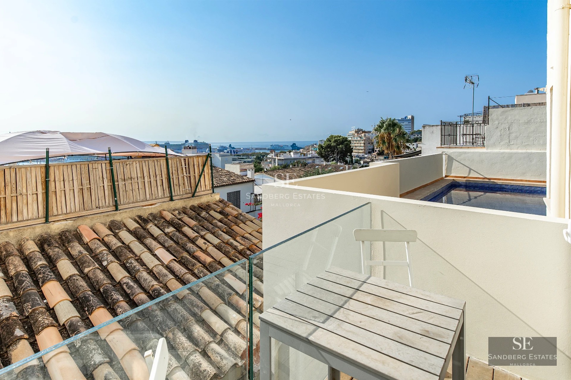 Bright living room with large windows overlooking the sea, modern and elegant design. Beige sofa, wooden coffee table, and minimalist decorative touches.