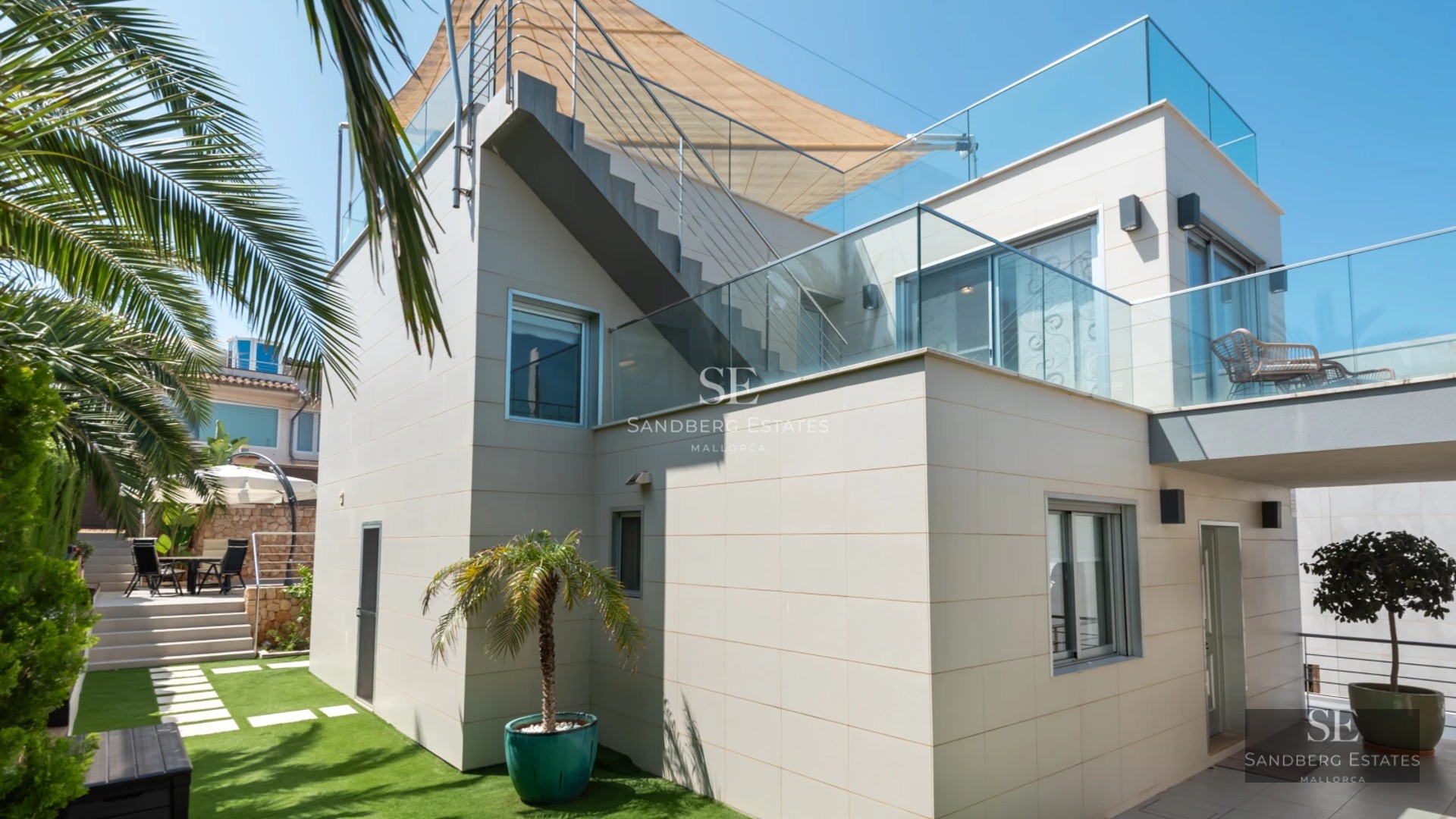 View of minimalist pool surrounded by terrace with sun loungers. Modern design with lush vegetation. Soft ambient lighting.
