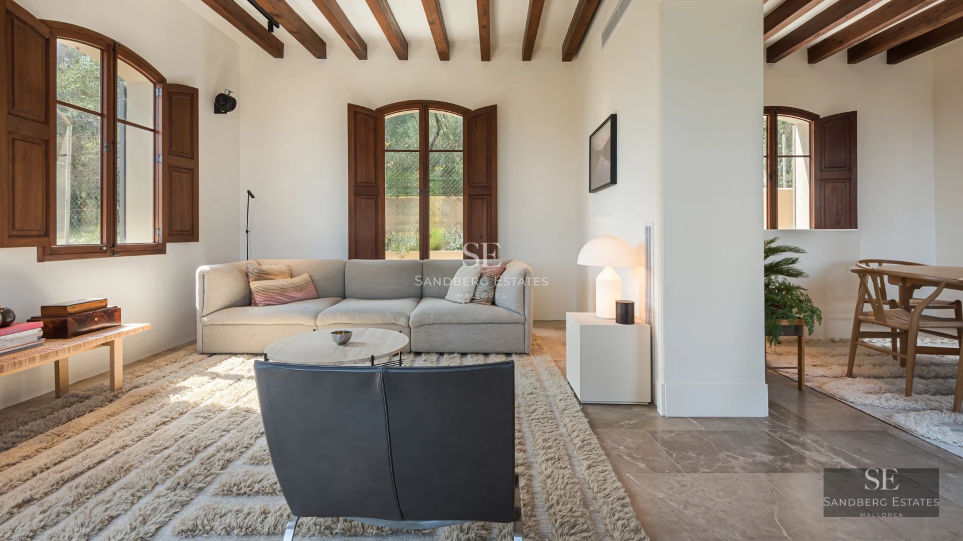 Spacious balcony with sea view, modern furniture, glass railing, wooden floor and retractable awning. Elegant and bright design.