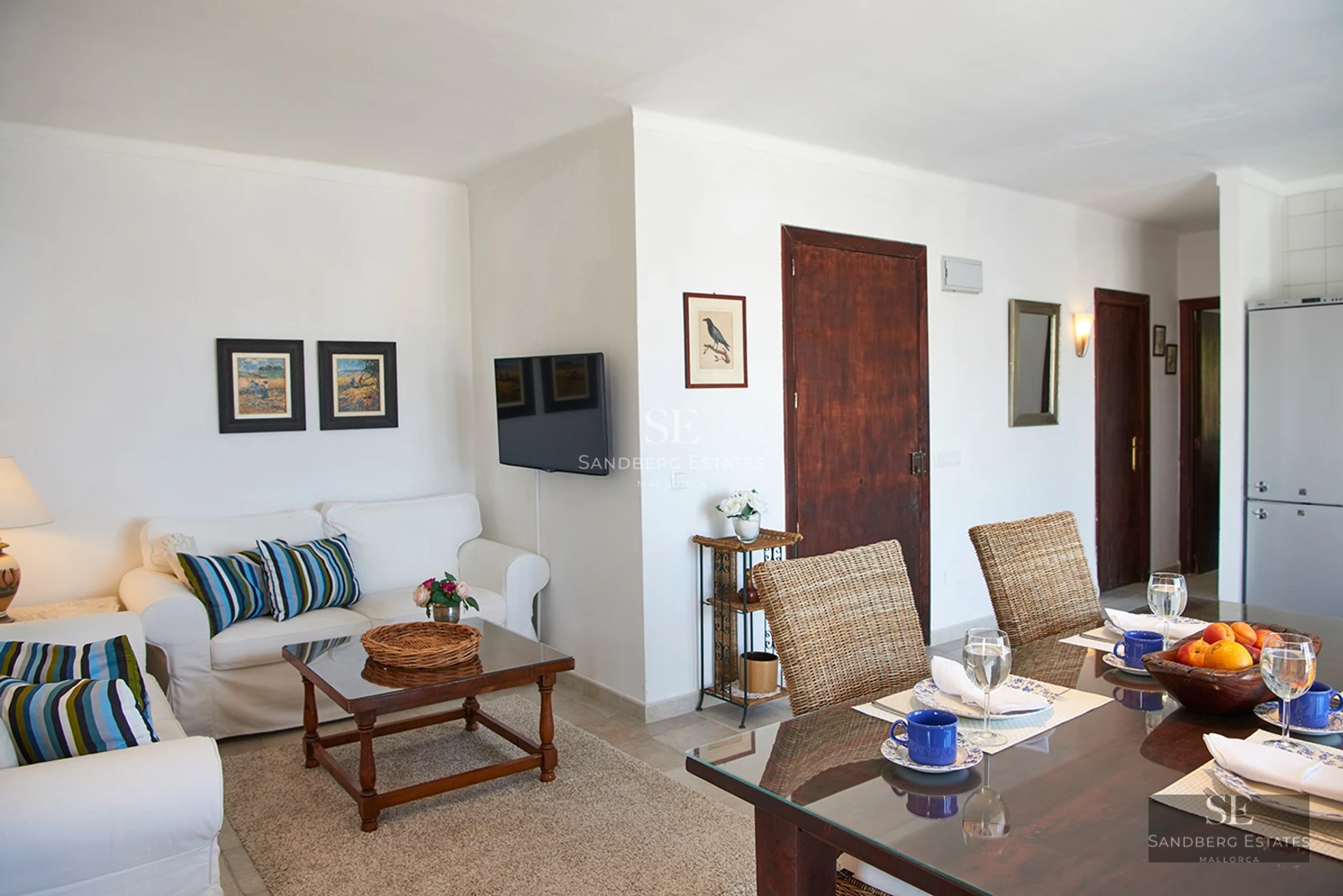 Spacious balcony with sea view. Modern outdoor furniture, glass railing, and tiled floor. Soft lighting and relaxing atmosphere.