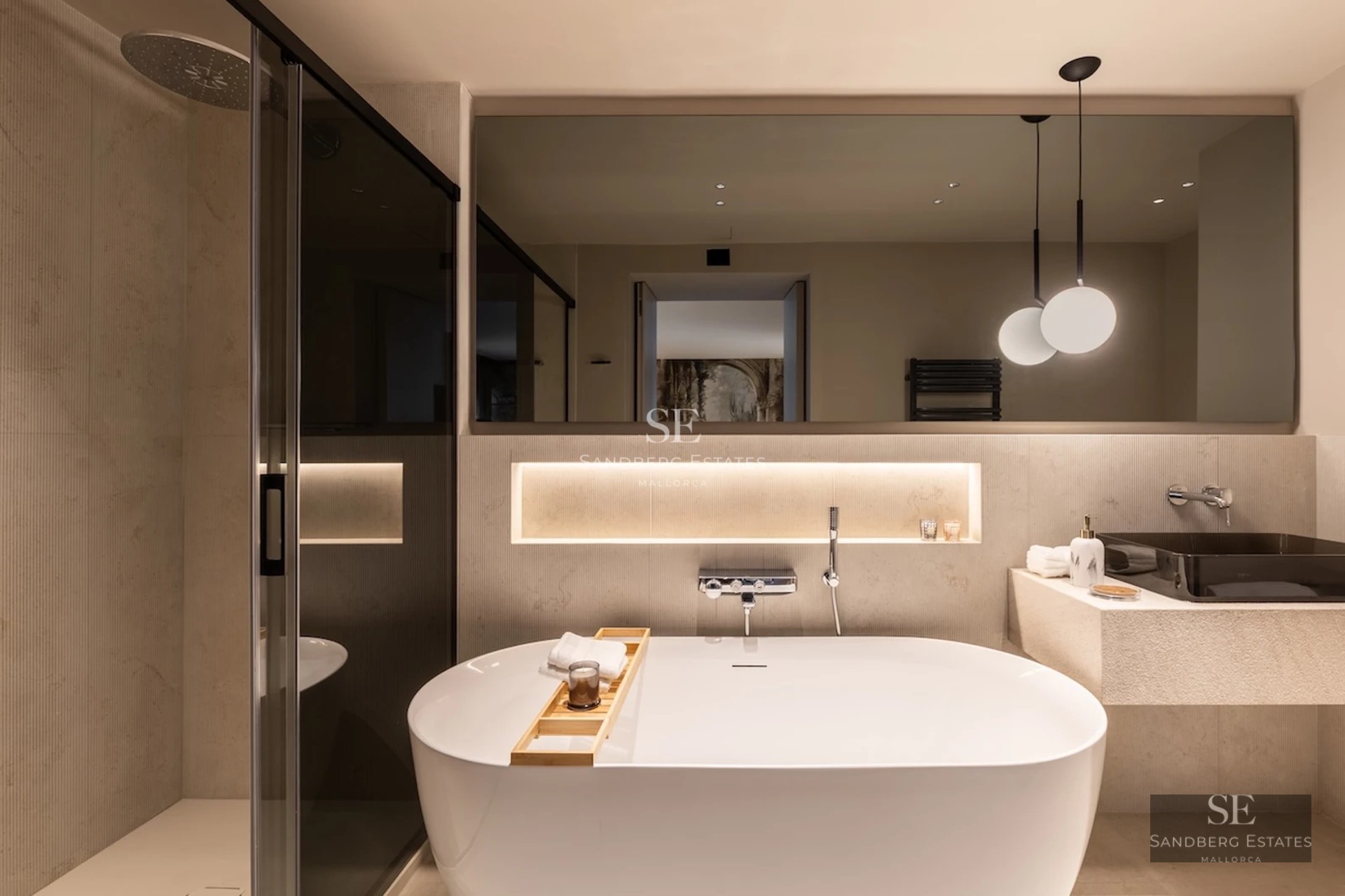 Spacious balcony with sea view. Glass railing, grey tile floor, and modern furniture. Soft ambient lighting.