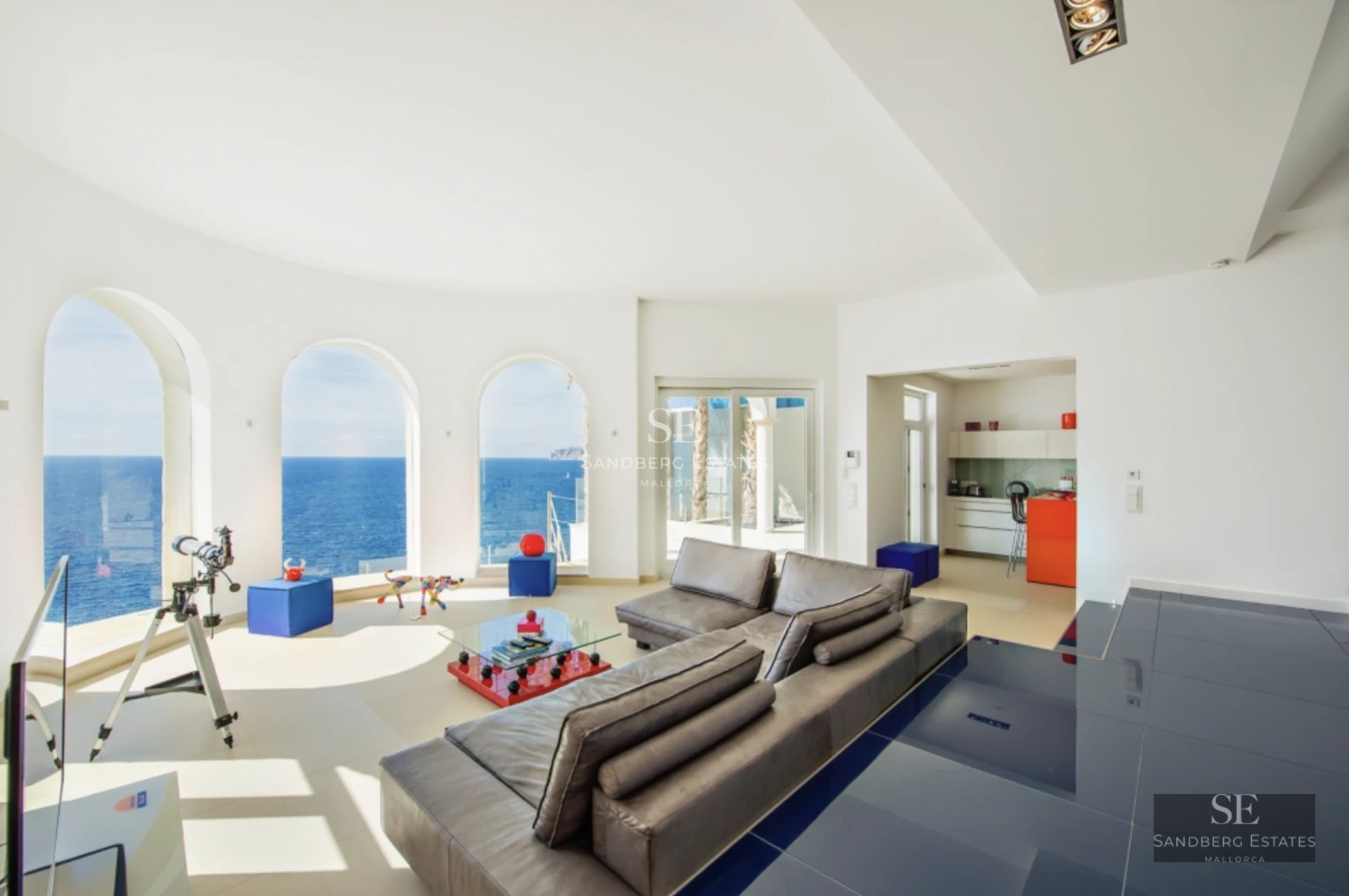 Spacious balcony with panoramic sea views. Modern design, glass railing, stylish outdoor furniture. Ambient lighting.