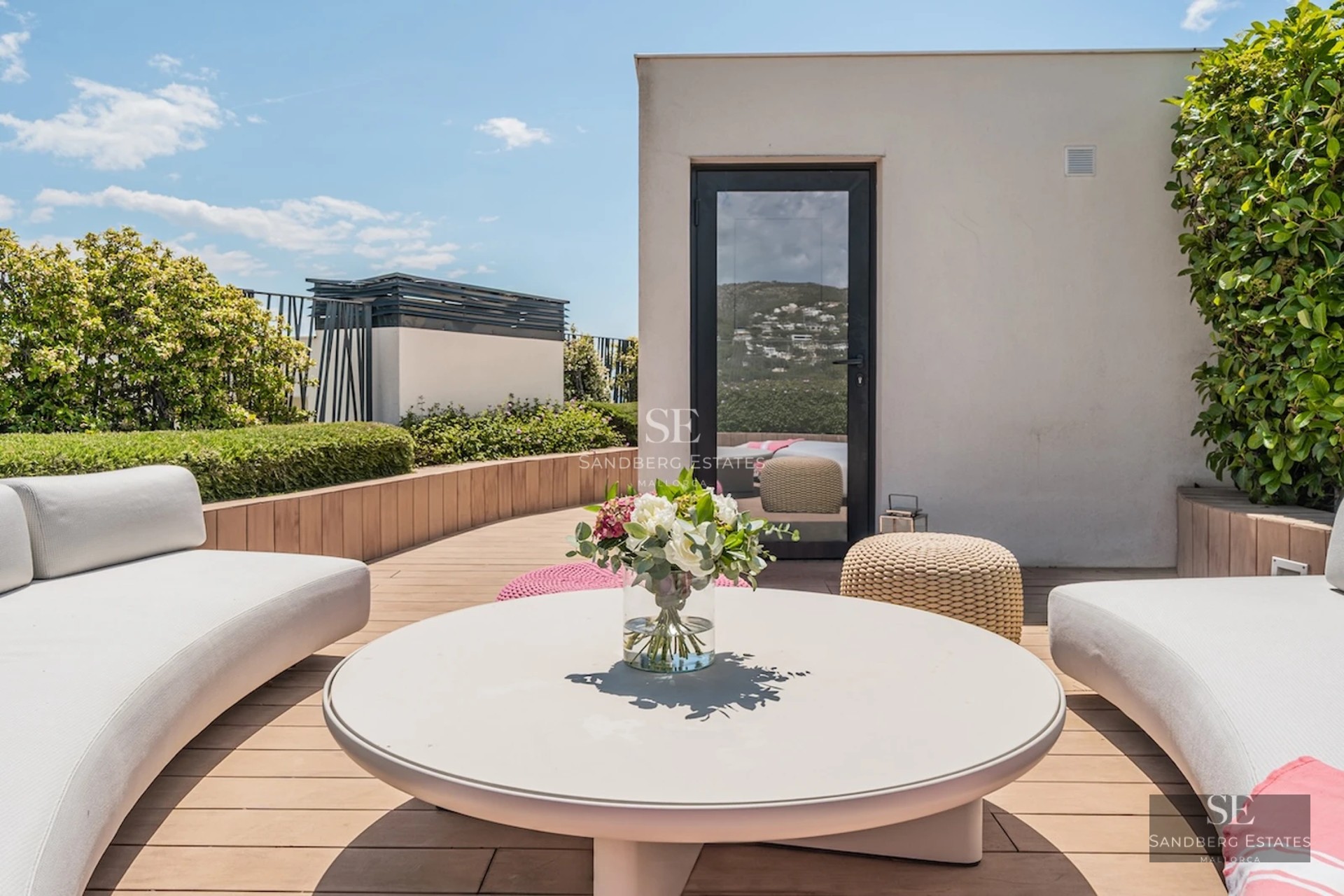 Spacious living room with panoramic windows, modern fireplace, wooden floors and elegant furniture. Panoramic outdoor views.