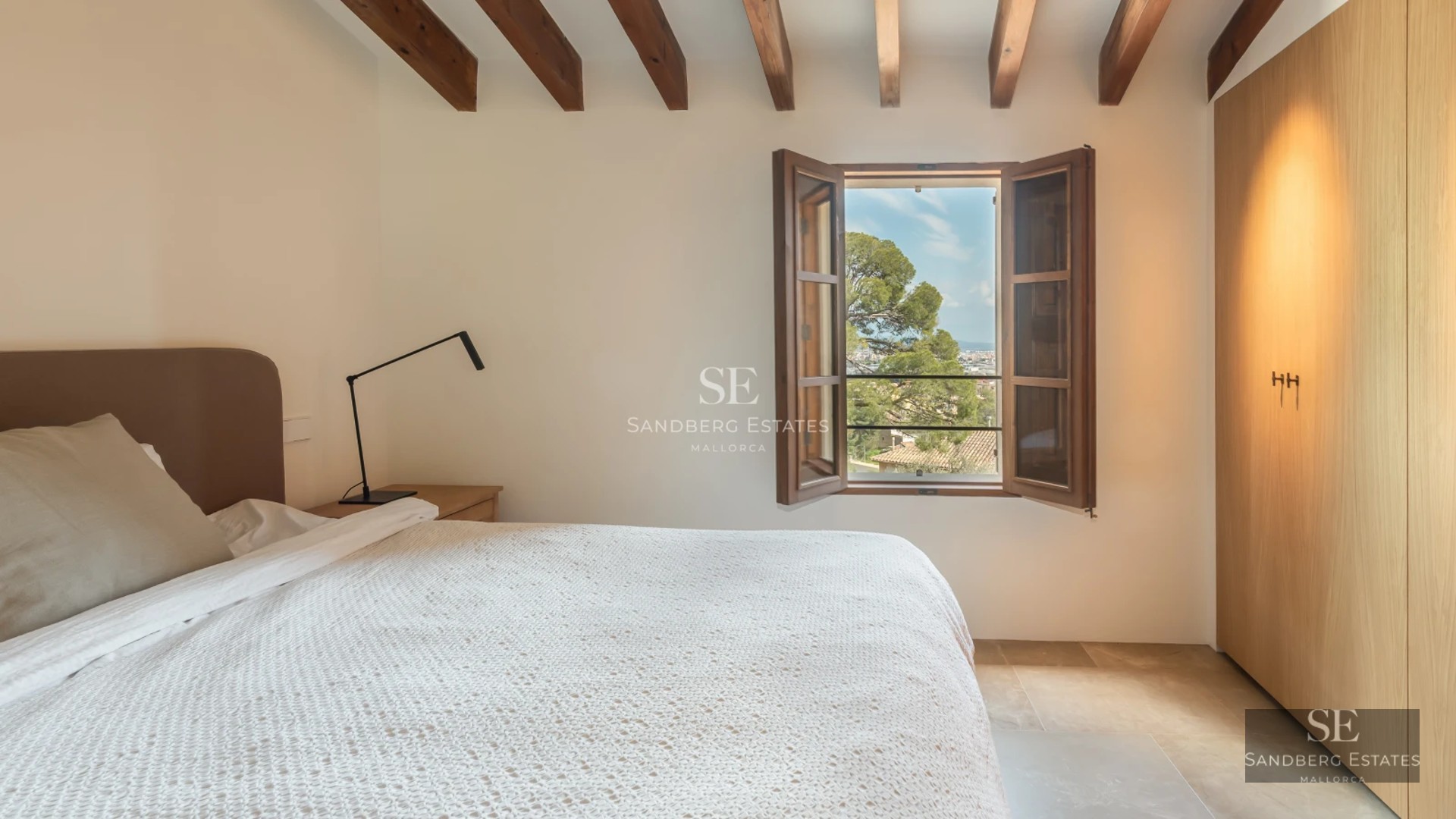 View of infinity pool surrounded by lush garden and modern villa with large windows and minimalist architecture.