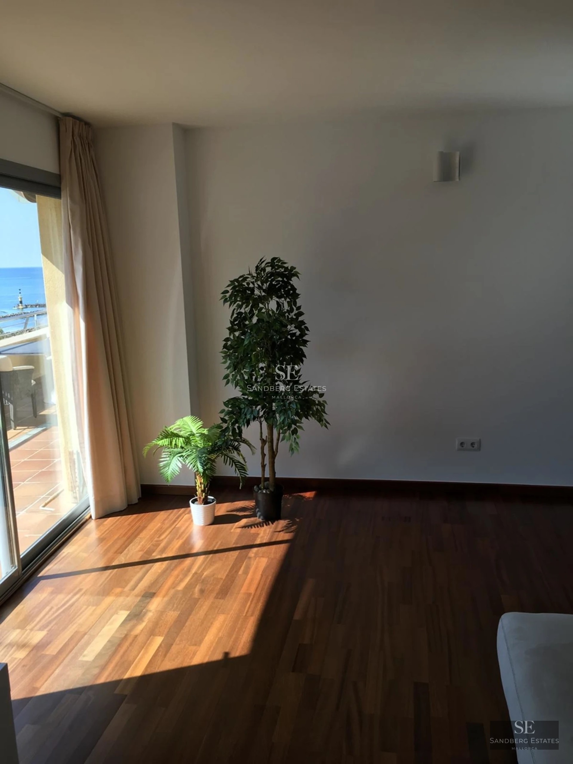 Grand salon avec baies vitrées, parquet clair, cheminée et mobilier moderne. Vues spectaculaires.