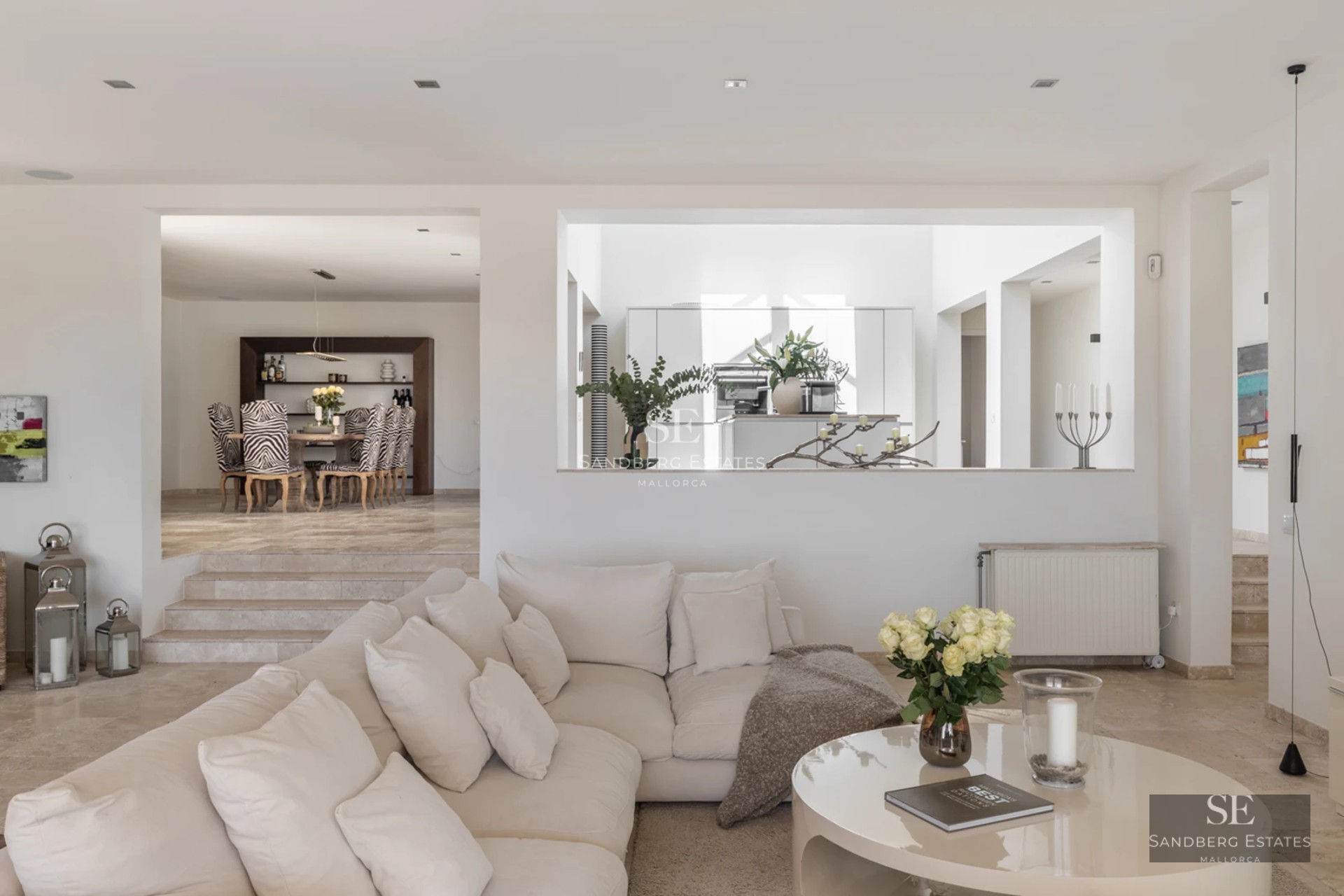 Spacious living room featuring large windows, natural light, modern design, wood flooring and garden and pool views.