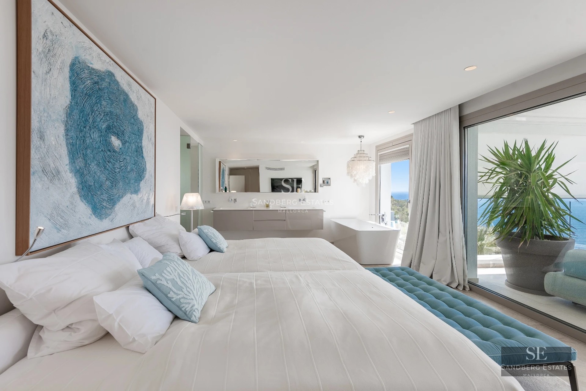 Bright interior with panoramic sea views. Modern design, large windows, light wood floors, and minimalist decor.